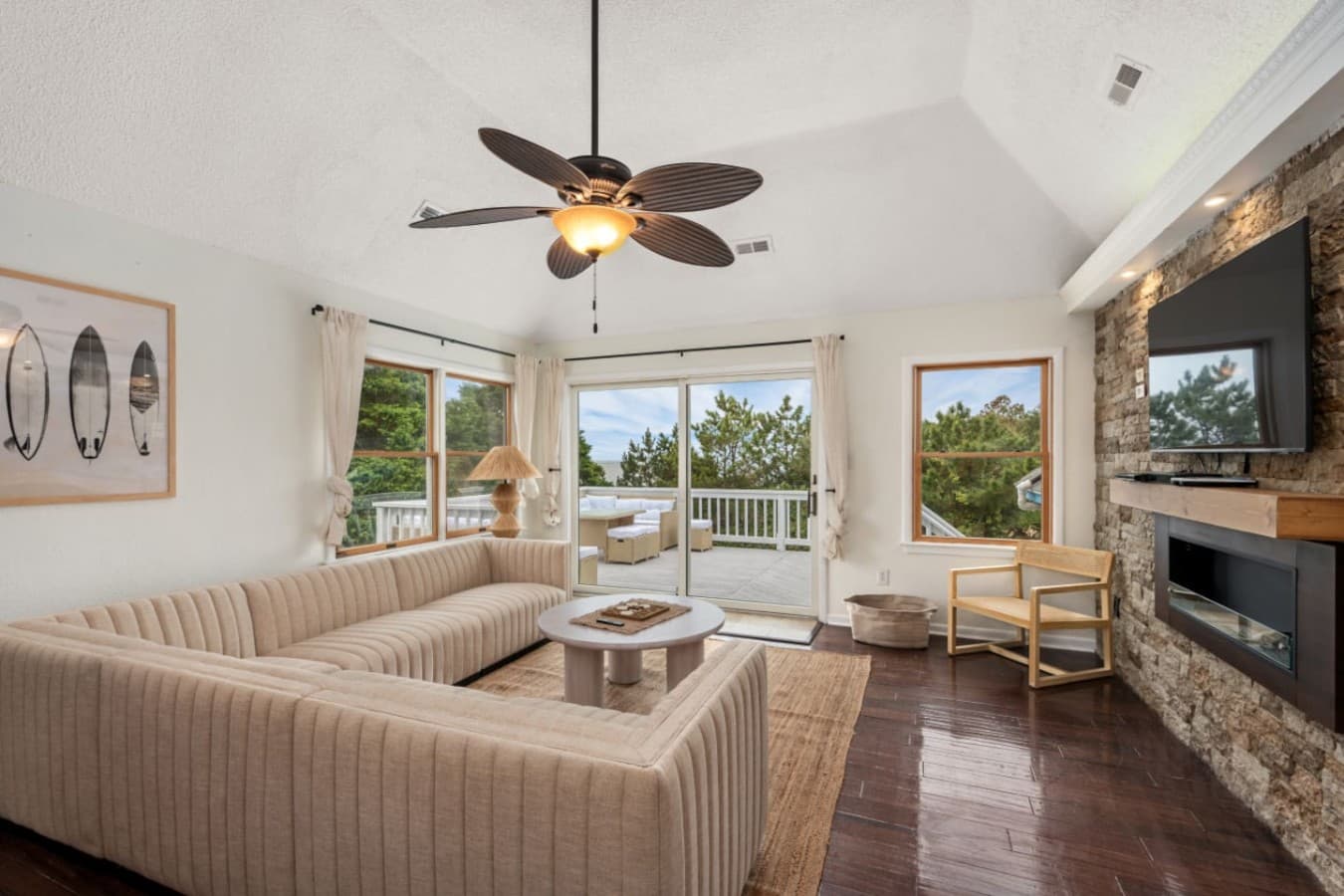 Bright living room w/ comfy seating, ceiling fan & easy flow to the outdoors.
