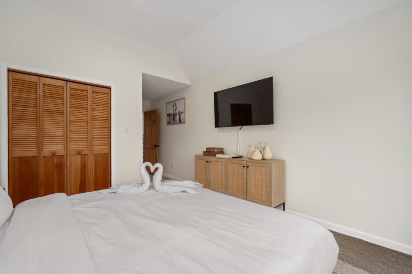 Simple, airy bedroom w/ TV & relaxed decor for unwinding after the day.