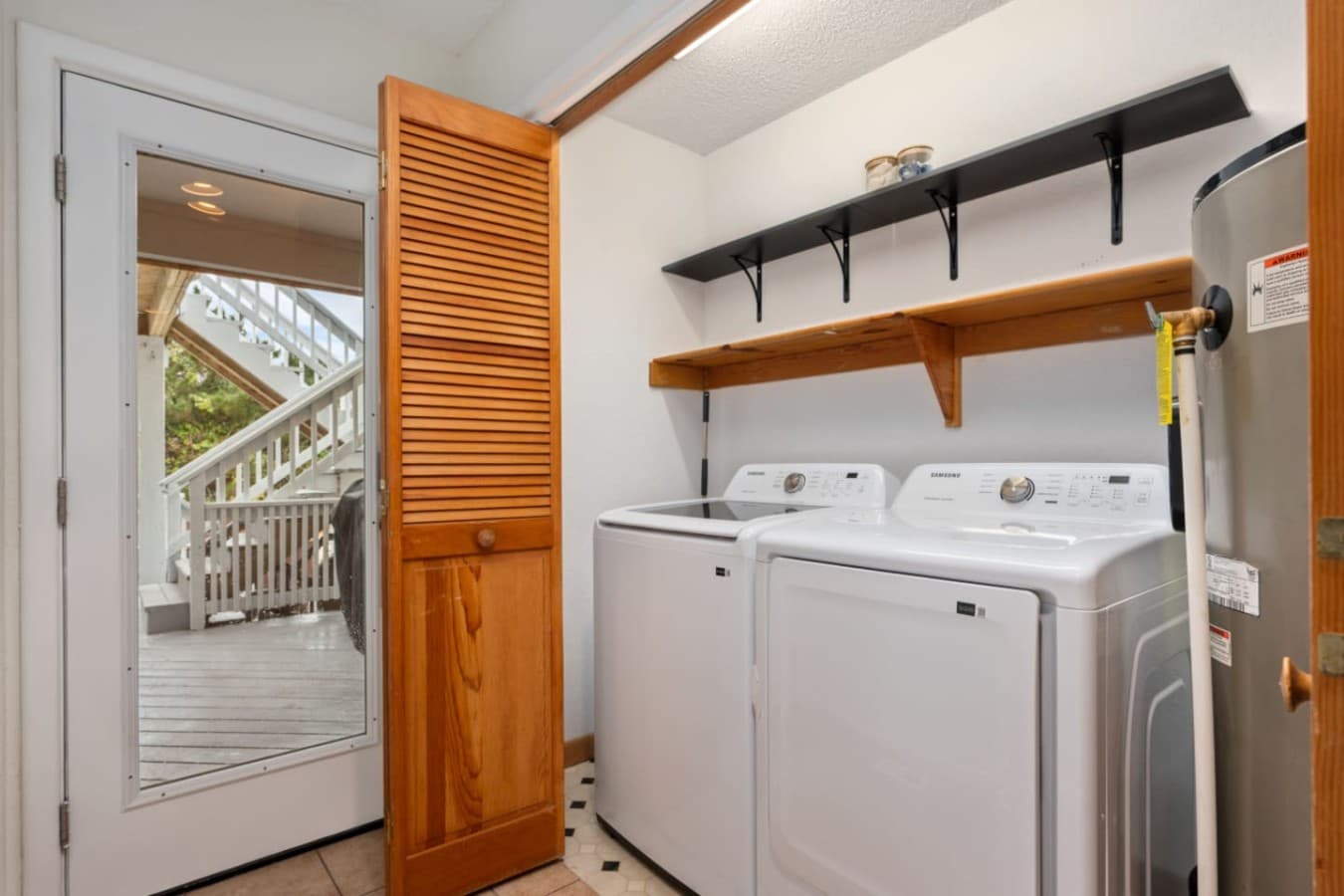 Laundry nook w/ washer & dryer neatly tucked behind louvered doors.
