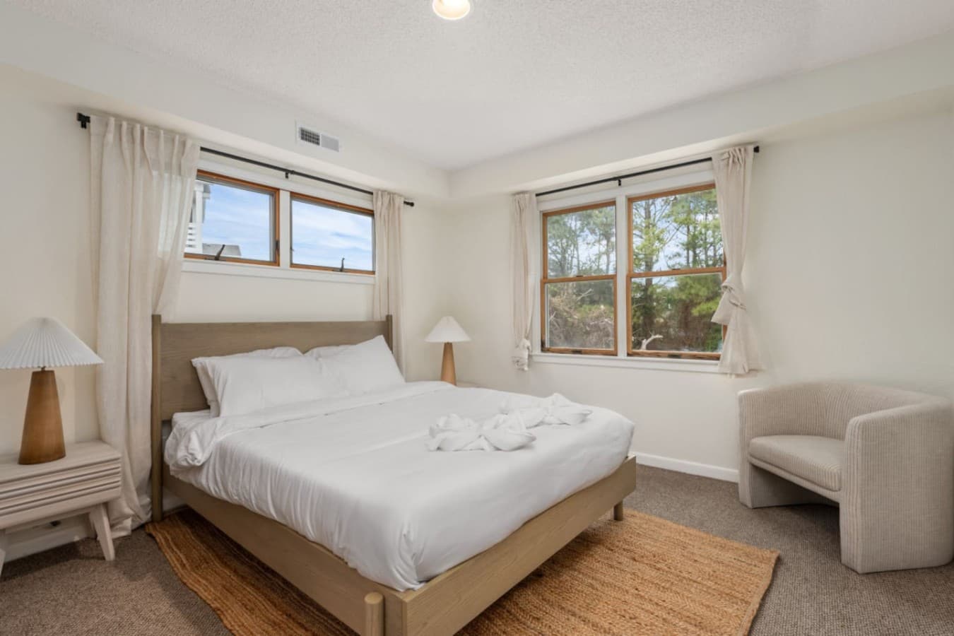 Calm bedroom retreat w/ soft light, neutral tones & inviting textures.
