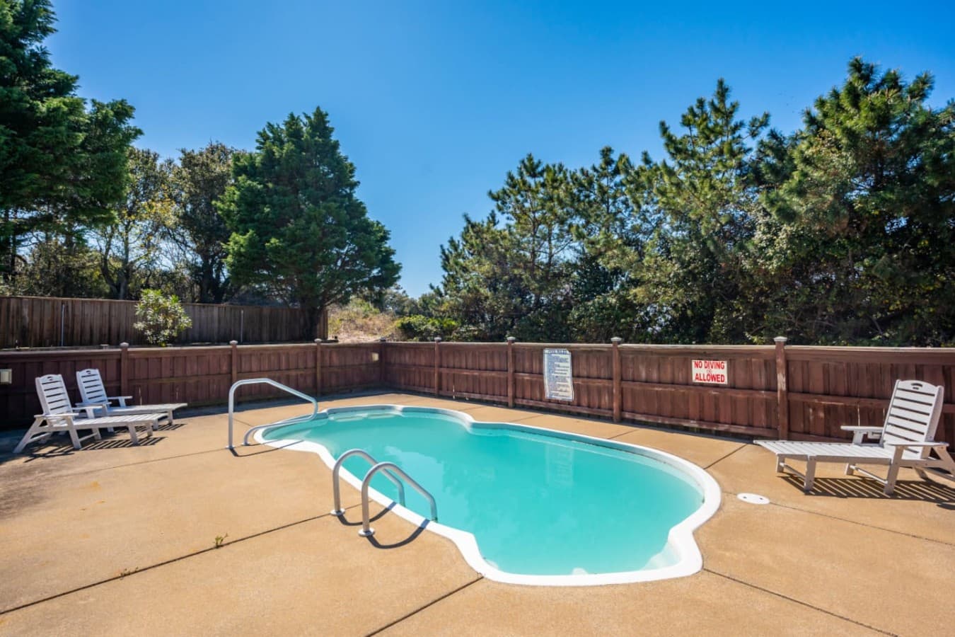 Private fenced pool area w/ loungers, perfect for sunny afternoons outdoors.