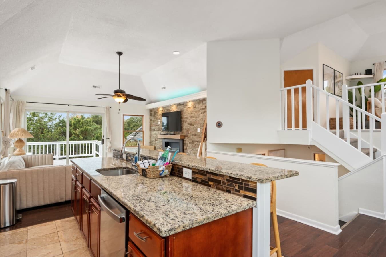 Bright kitchen w/ granite counters opening to the main living space.