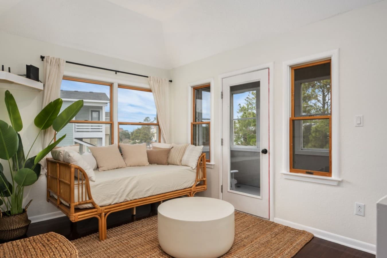 Cozy sitting nook by large windows, perfect for reading or morning coffee.