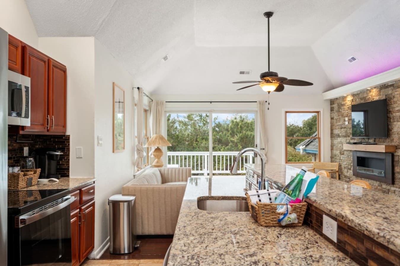 Spacious living room w/ TV, ceiling fan & sliding doors to the deck.
