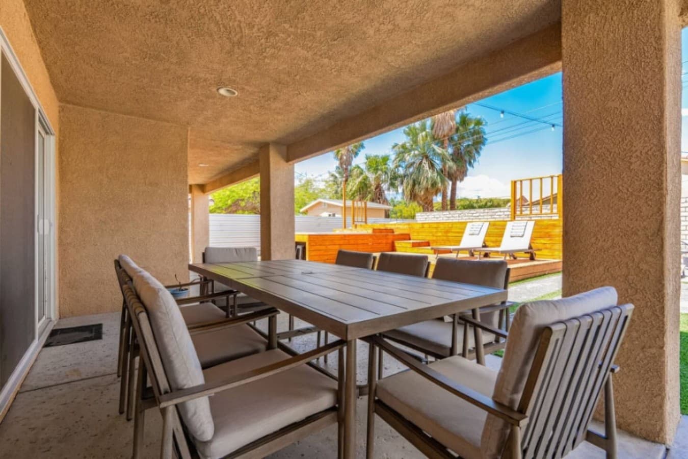 Covered patio seating overlooking the pool area, perfect for shaded lounging any time of day.