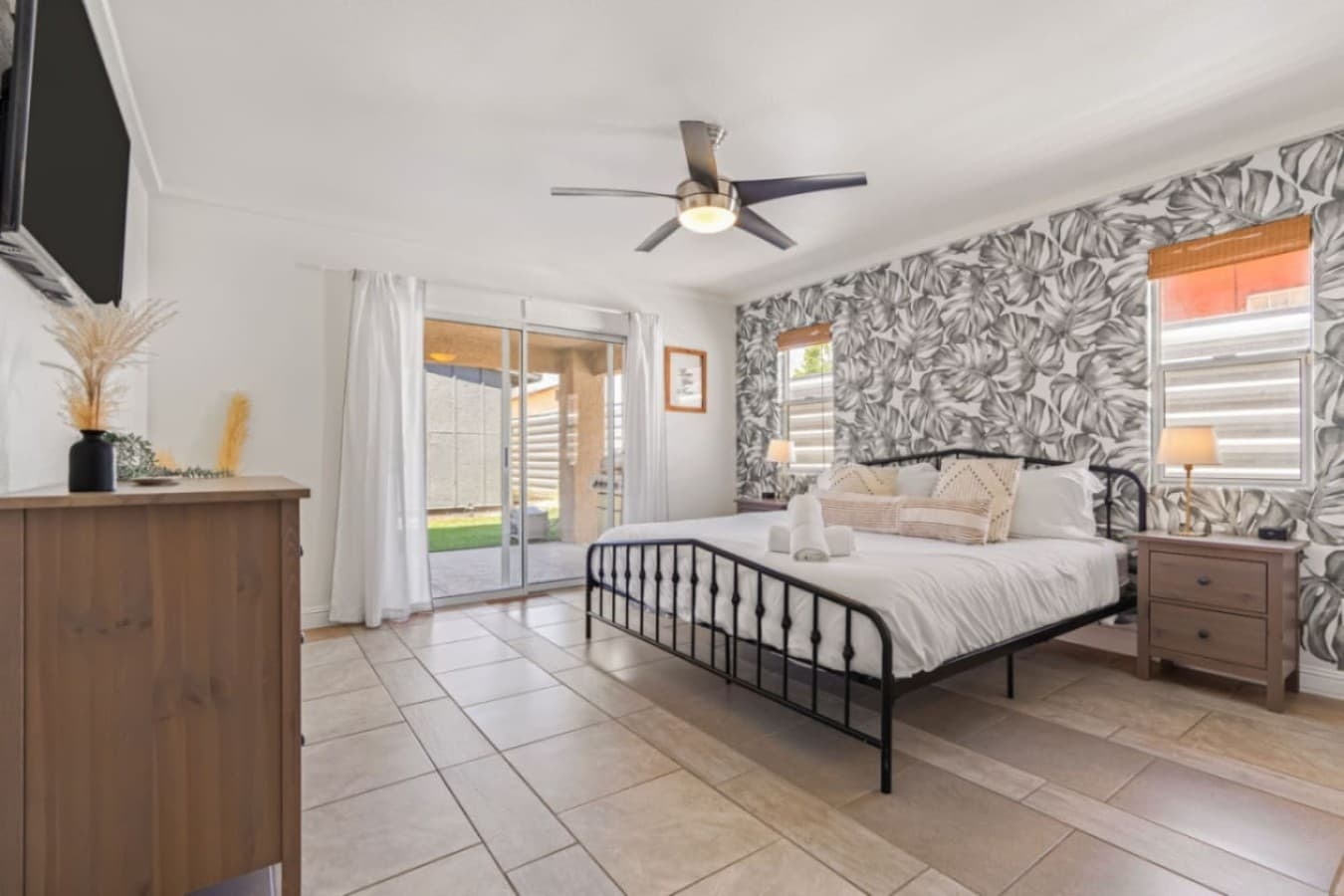 Airy bedroom layout w/ twin beds, ceiling fan & natural light filling the space.