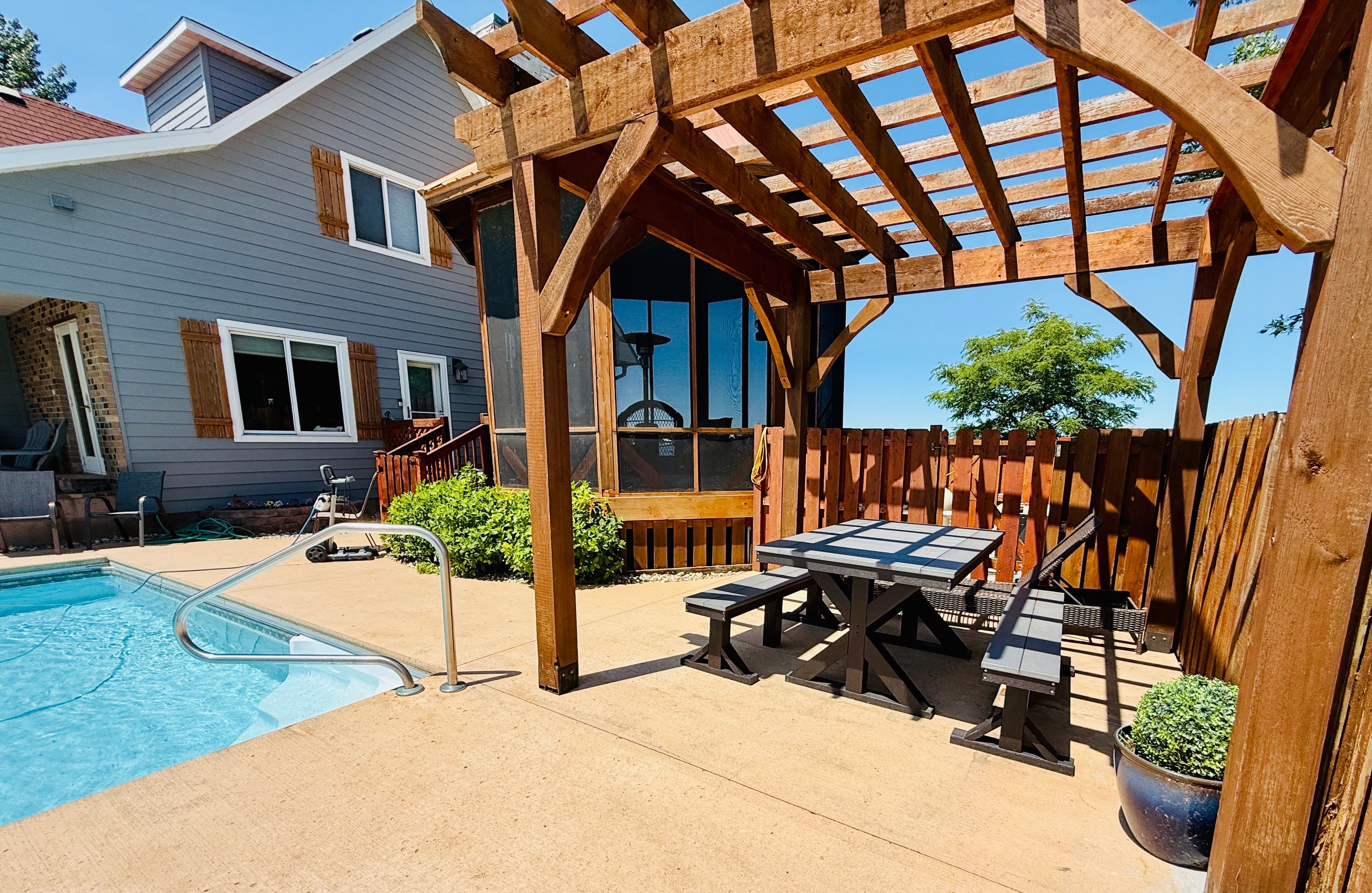 Picnic poolside under our shaded wooden pergola, ideal for family gatherings.