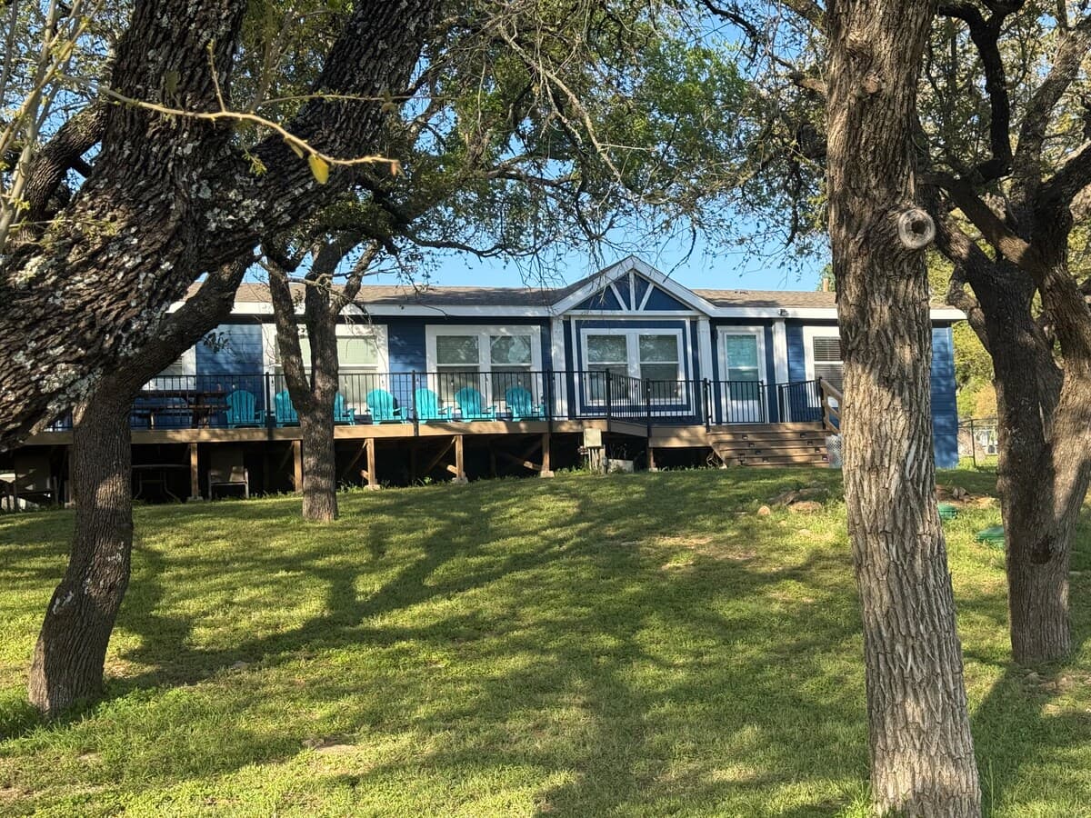 Exterior through mature oak trees. 