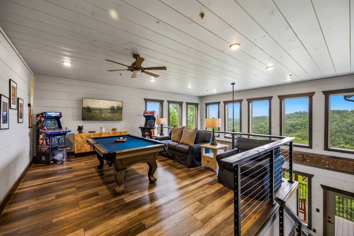 A spacious upstairs game room with arcade games and a pool table