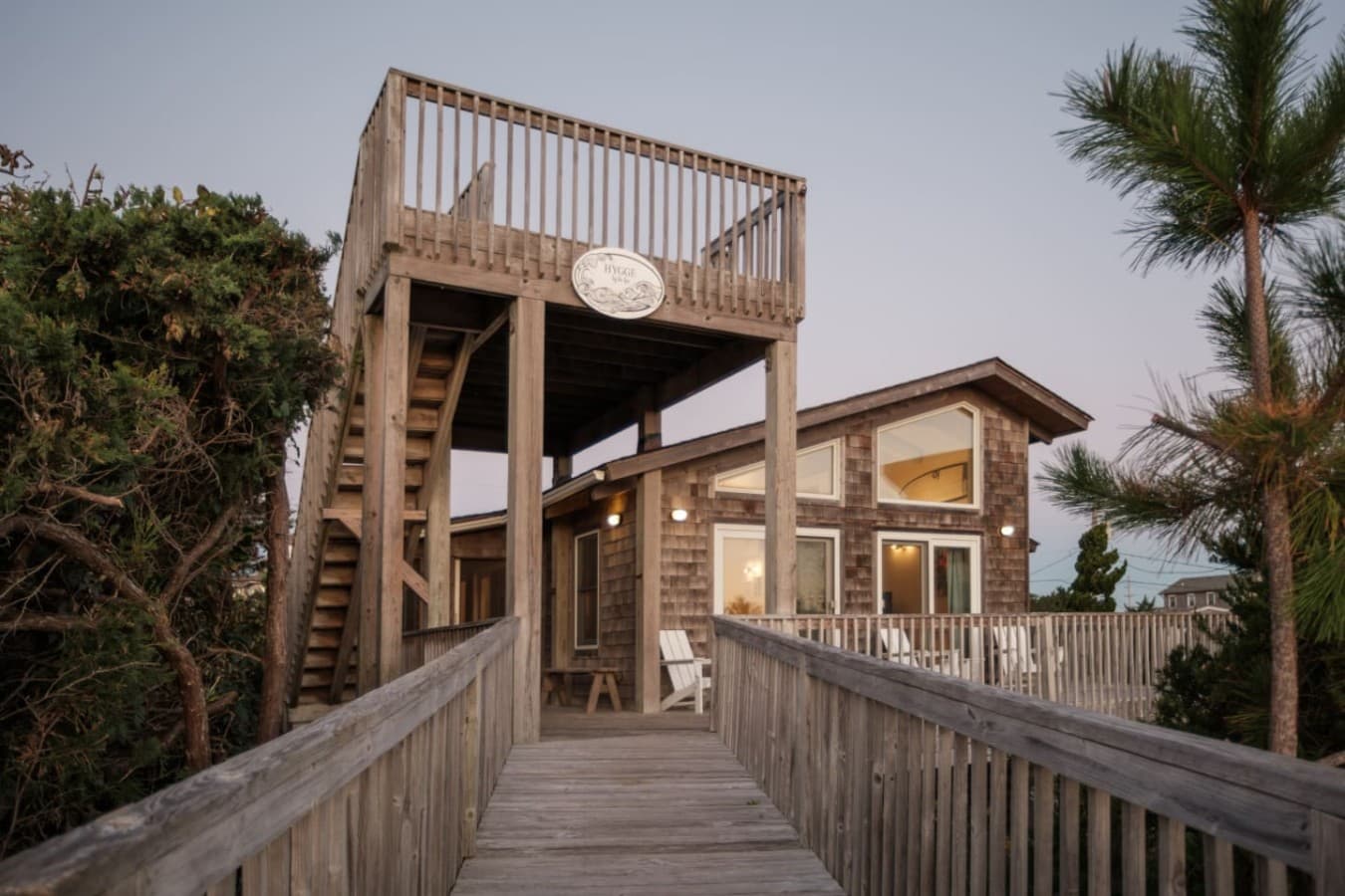 Elevated exterior walkway leading to the home, surrounded by natural greenery.