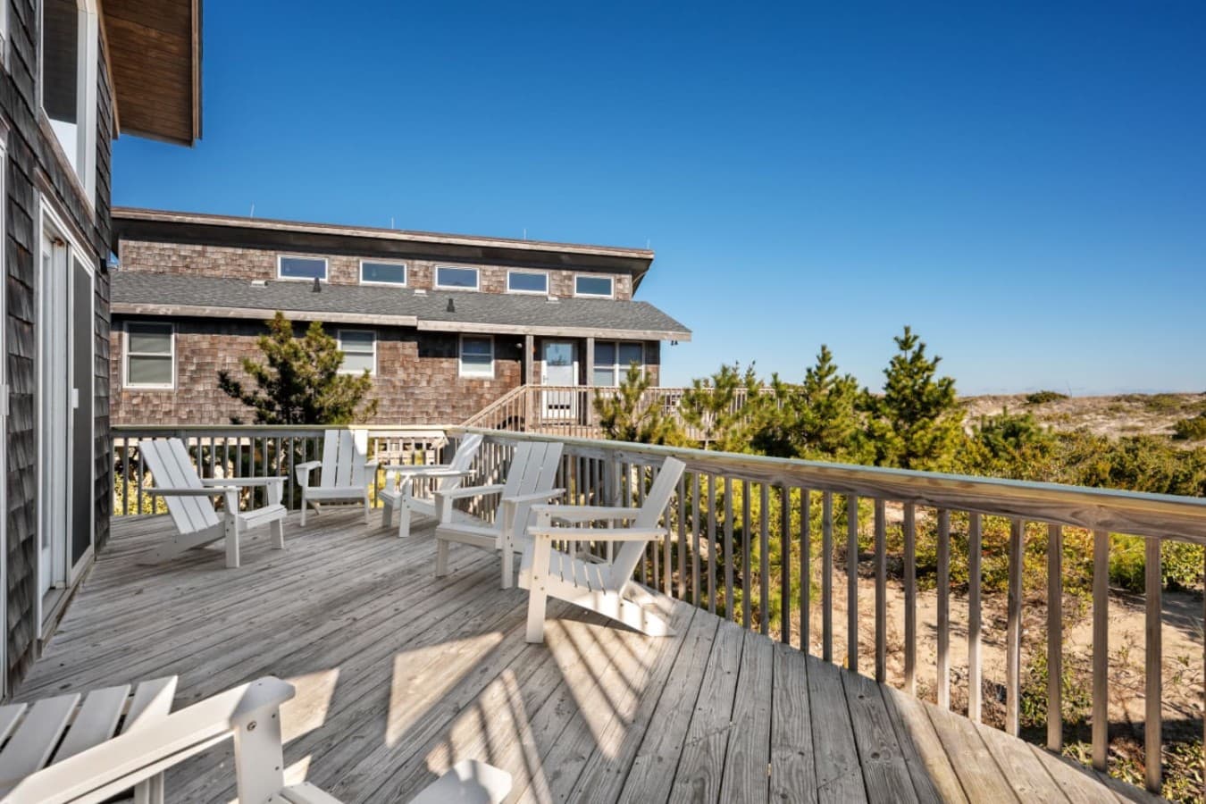 Outdoor deck w/ seating to soak in fresh air & neighborhood views under blue skies.