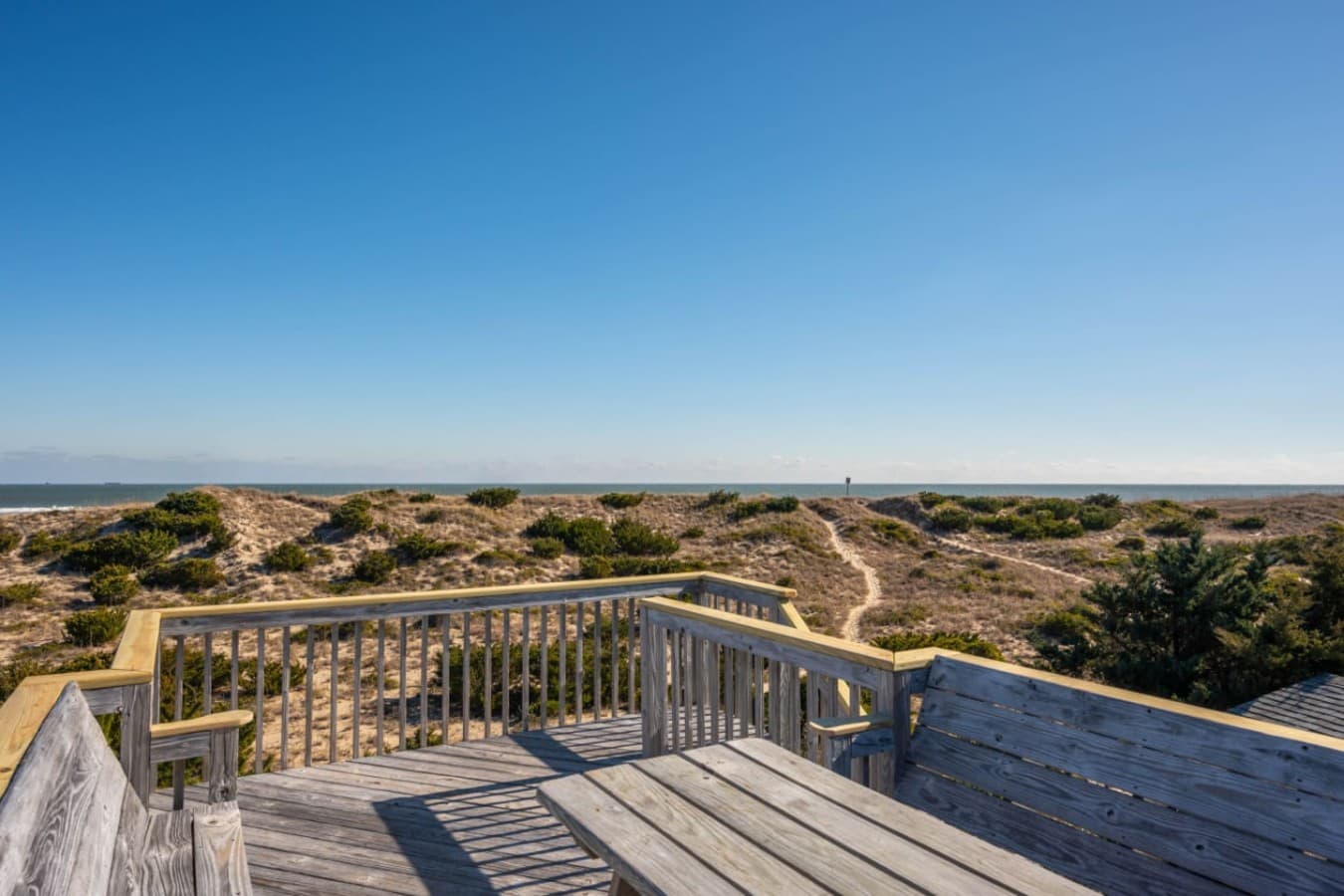 Upper deck view w/ railings framing expansive coastal scenery in every direction.