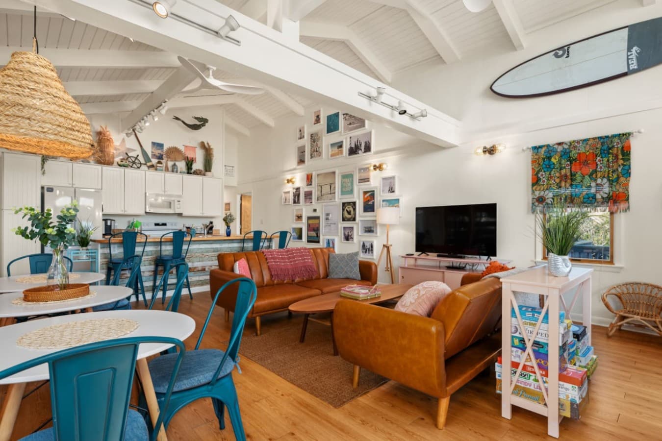 Bright living area w/ comfy seating, playful decor & sunlight filling the space.