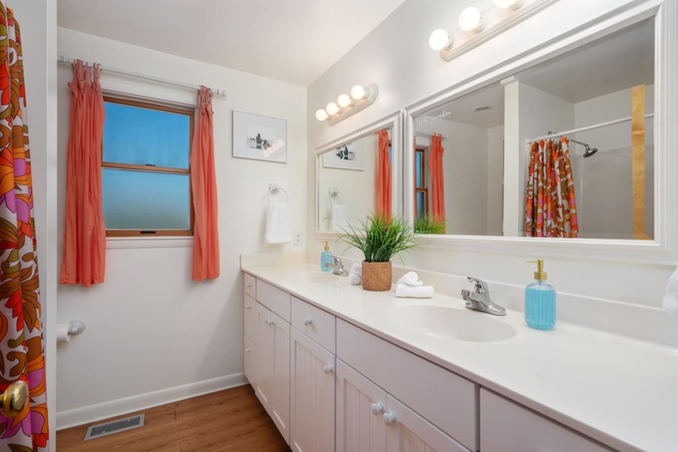 Clean bathroom vanity w/ wide counter, mirror lighting & fresh coastal accents.