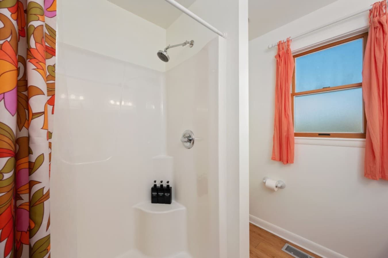 Walk-in shower w/ crisp tile, bright light & a refreshing, uncluttered feel.