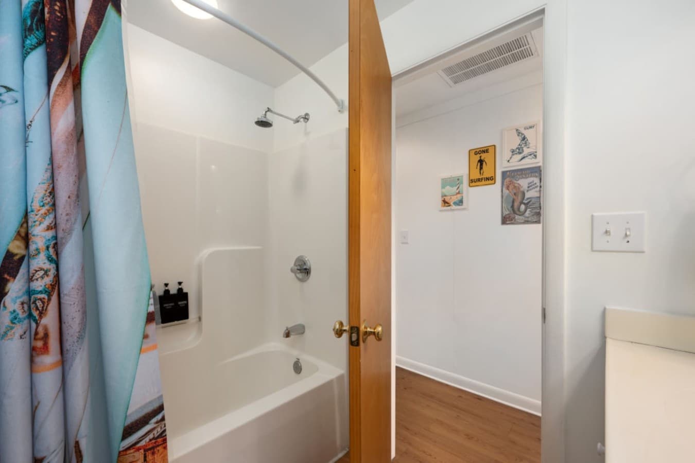Bathroom w/ a tub-shower combo & bright curtain — easy for rinsing off sand and salt.