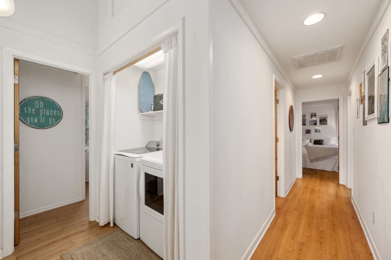 Hallway laundry nook w/ washer & dryer behind a curtain for easy mid-stay loads.