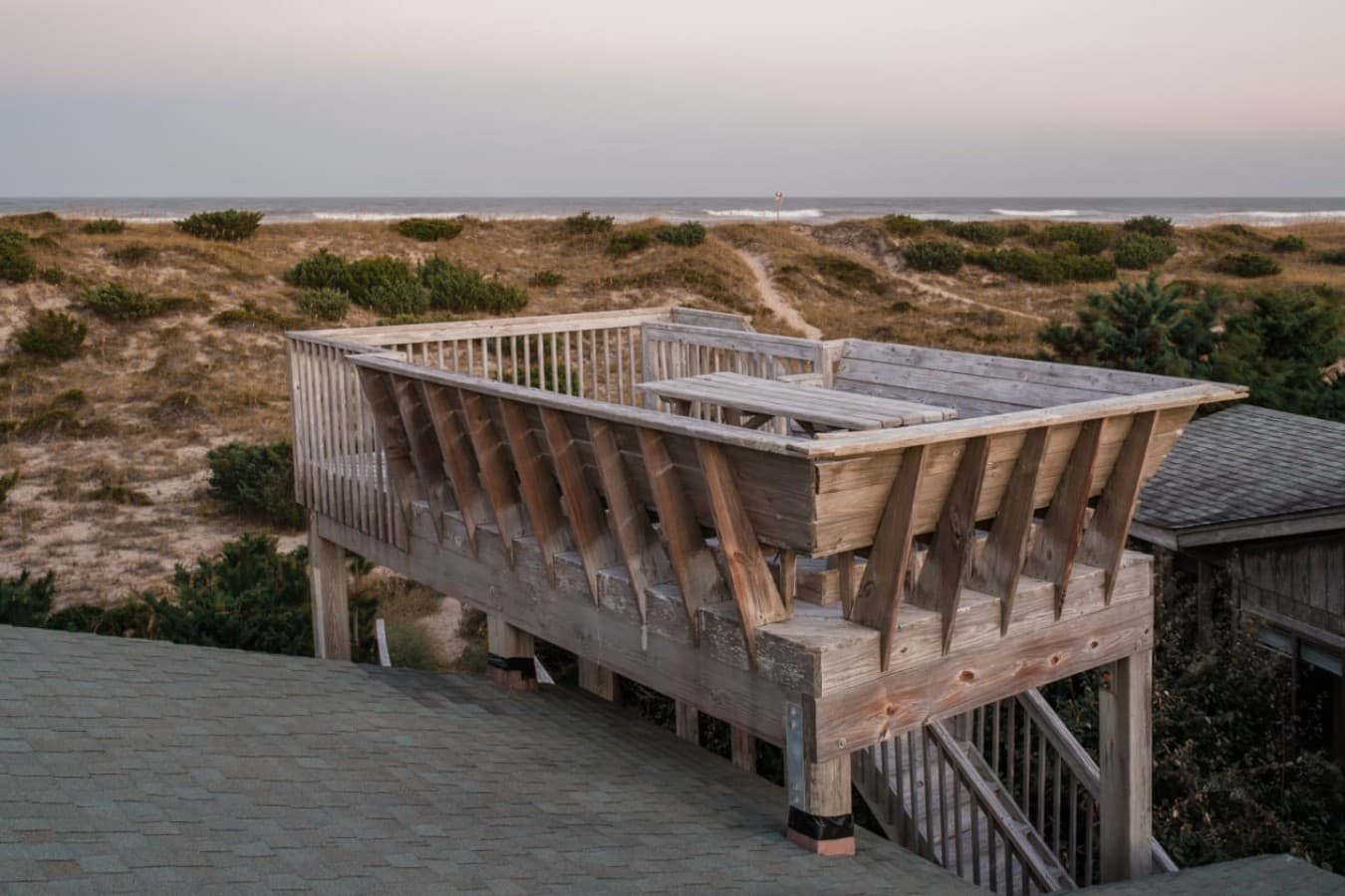 Rooftop sun deck built above the roofline, looking out over the dunes to the ocean.