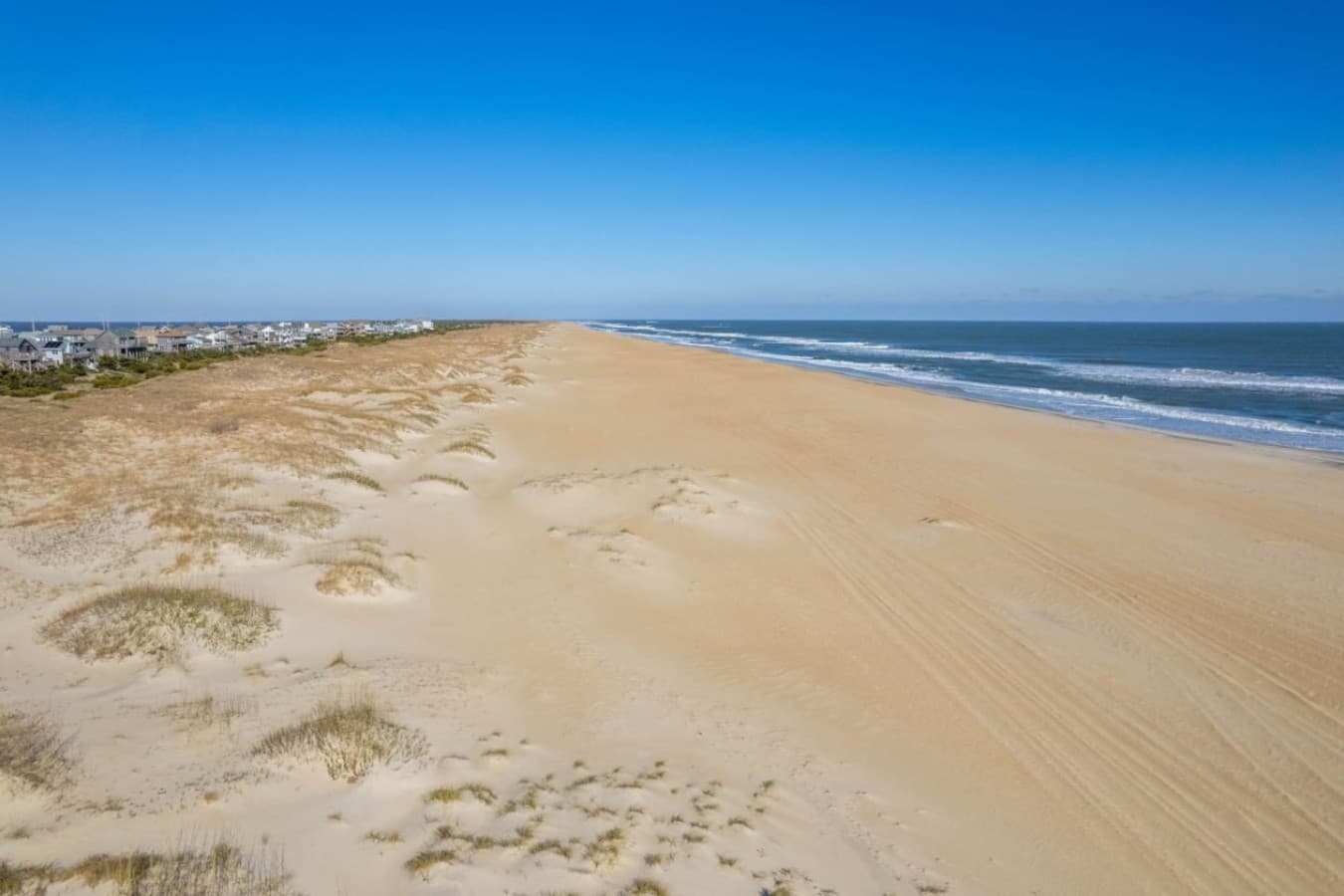 Wide stretch of beach & rolling surf seen from the dune beside the house.