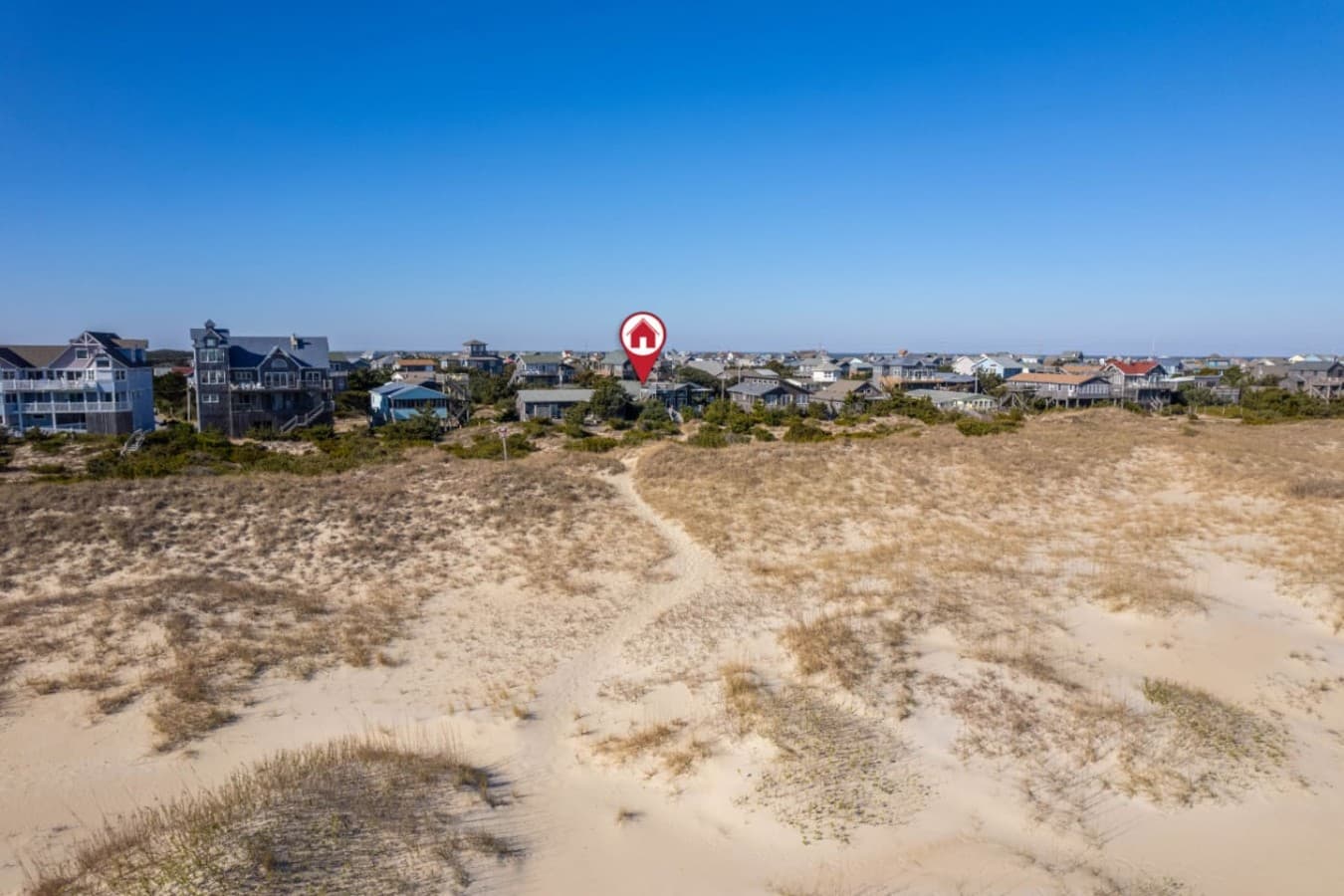 Aerial over the dune looking back at the house & the surrounding beach neighborhood.