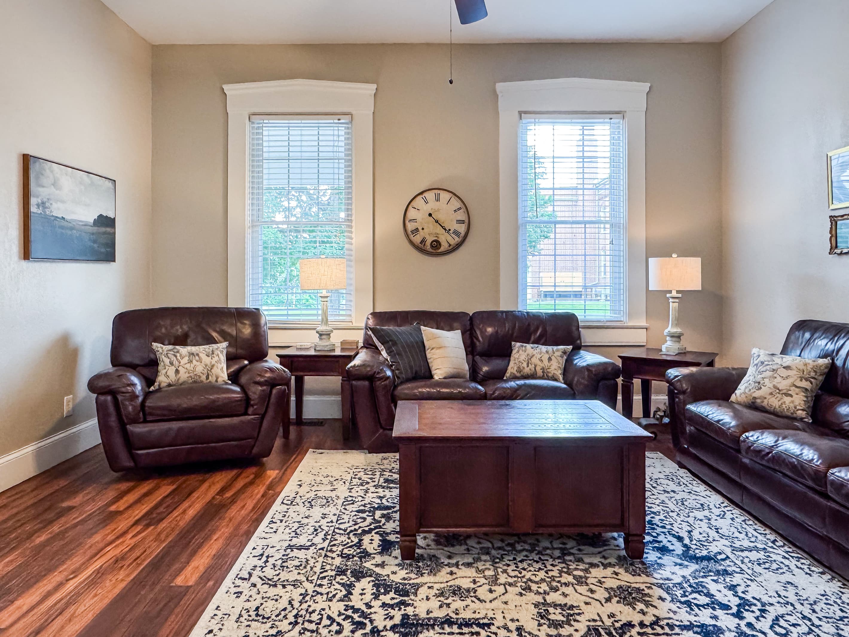 Warm and inviting Great Room with comfy leather couch, loveseat and recliner just off the kitchen for a perfect setup for families/groups to relax and reconnect at Mini Aussie Cottage.