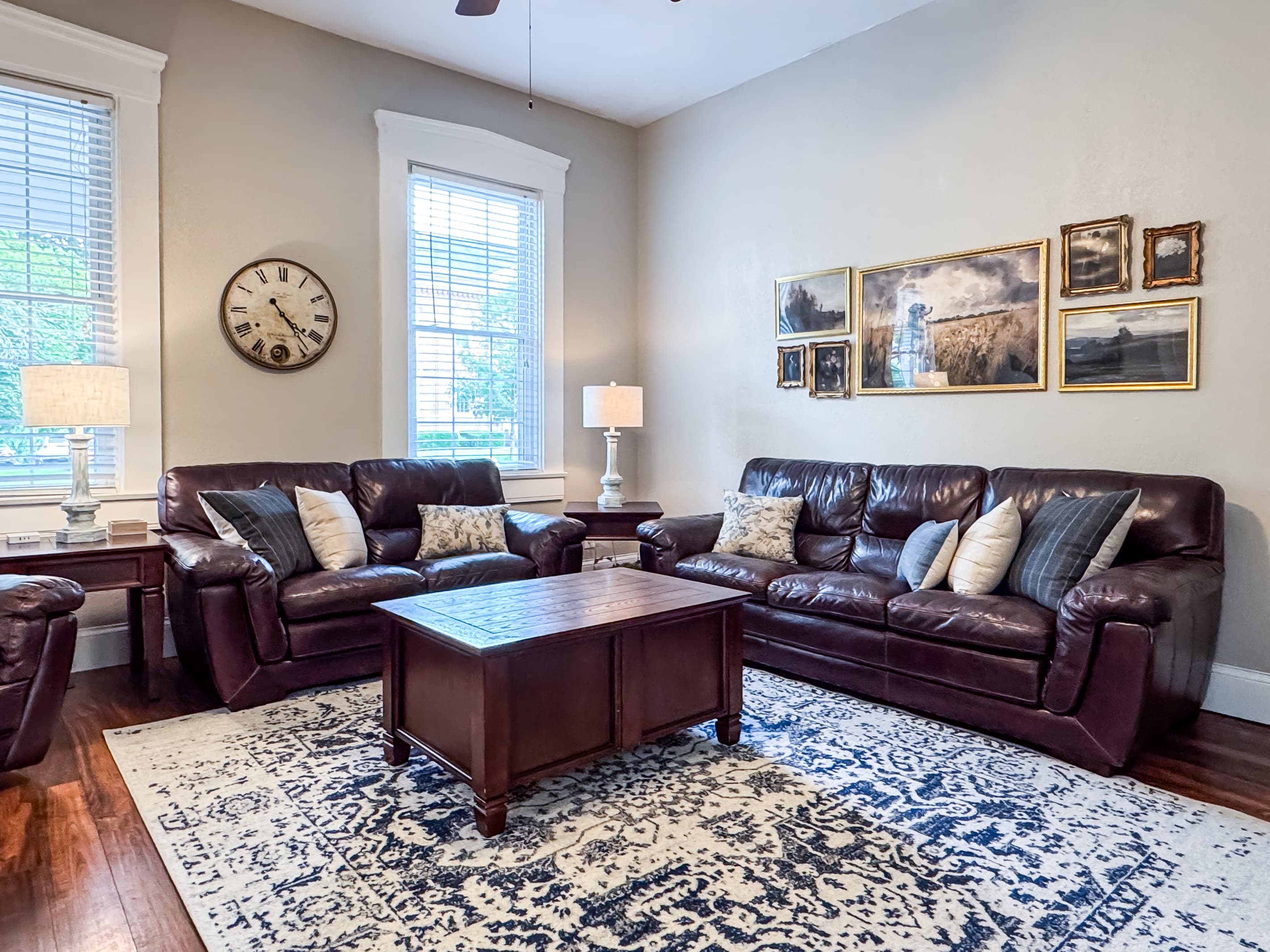 Warm and inviting Great Room with comfy leather couch, loveseat and recliner just off the kitchen for a perfect setup for families/groups to relax and reconnect at Mini Aussie Cottage.