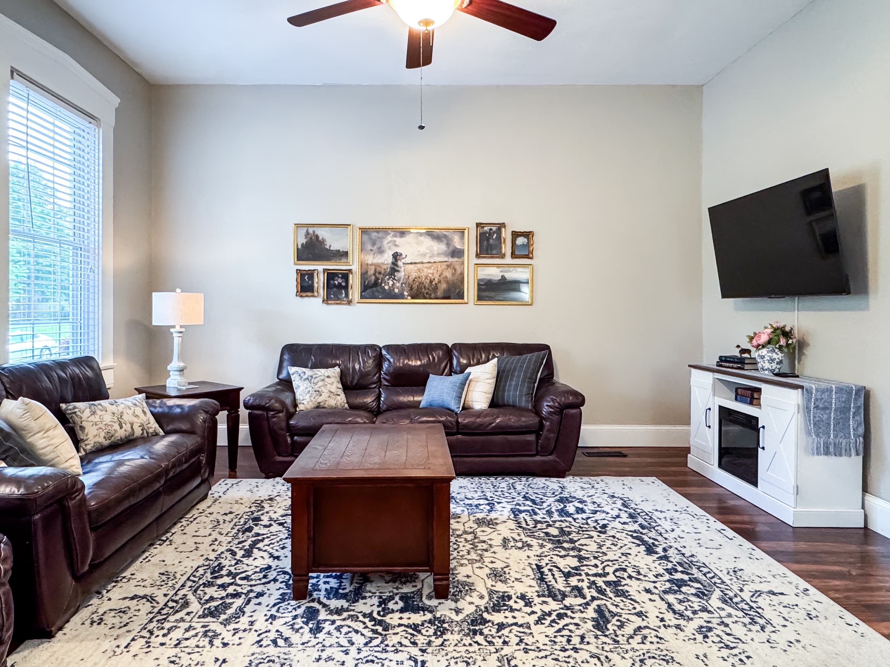 Warm and inviting Great Room with comfy leather couch, loveseat and recliner just off the kitchen for a perfect setup for families/groups to relax and reconnect at Mini Aussie Cottage.