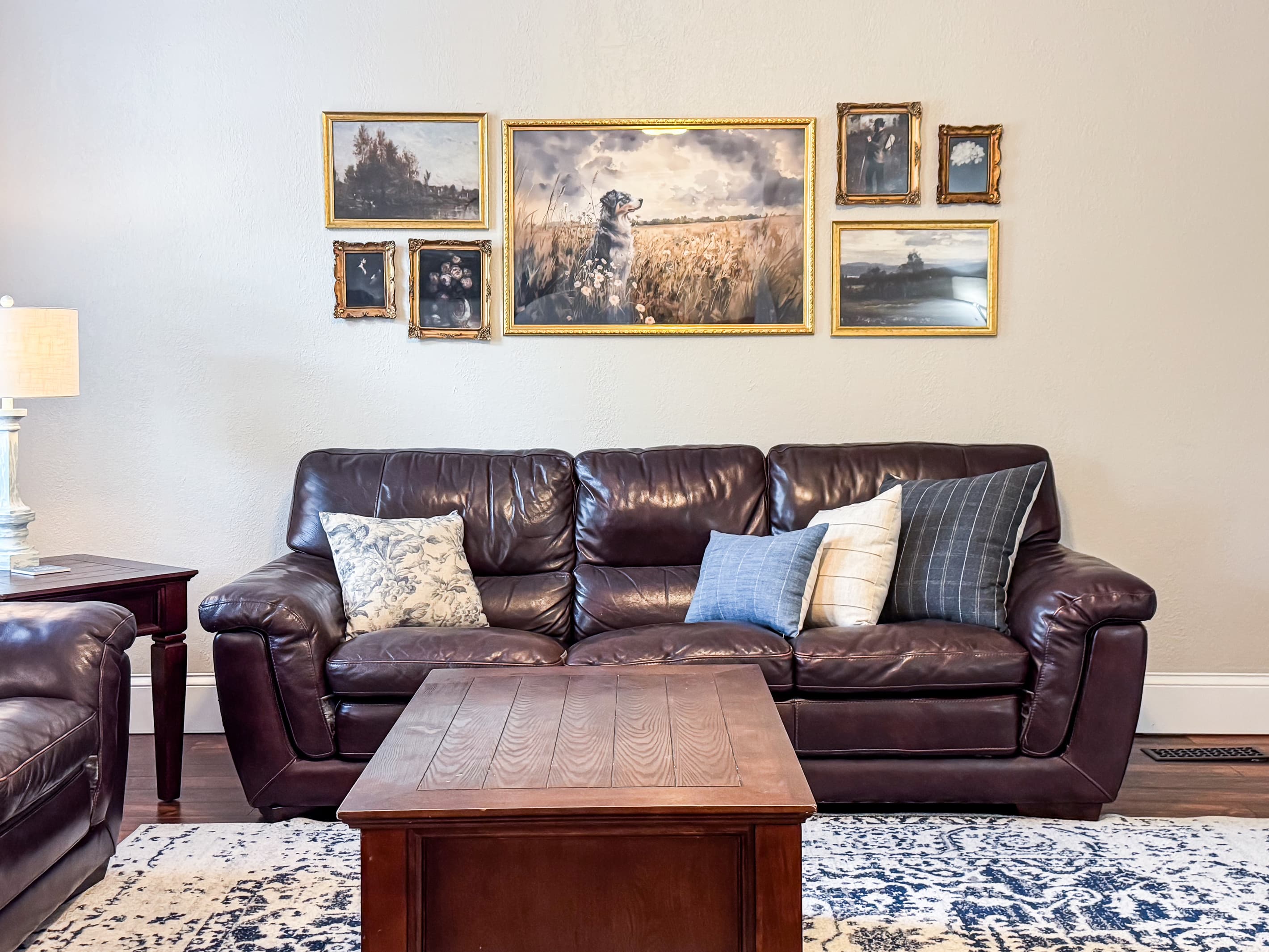 Warm and inviting Great Room with comfy leather couch, loveseat and recliner just off the kitchen for a perfect setup for families/groups to relax and reconnect at Mini Aussie Cottage.
