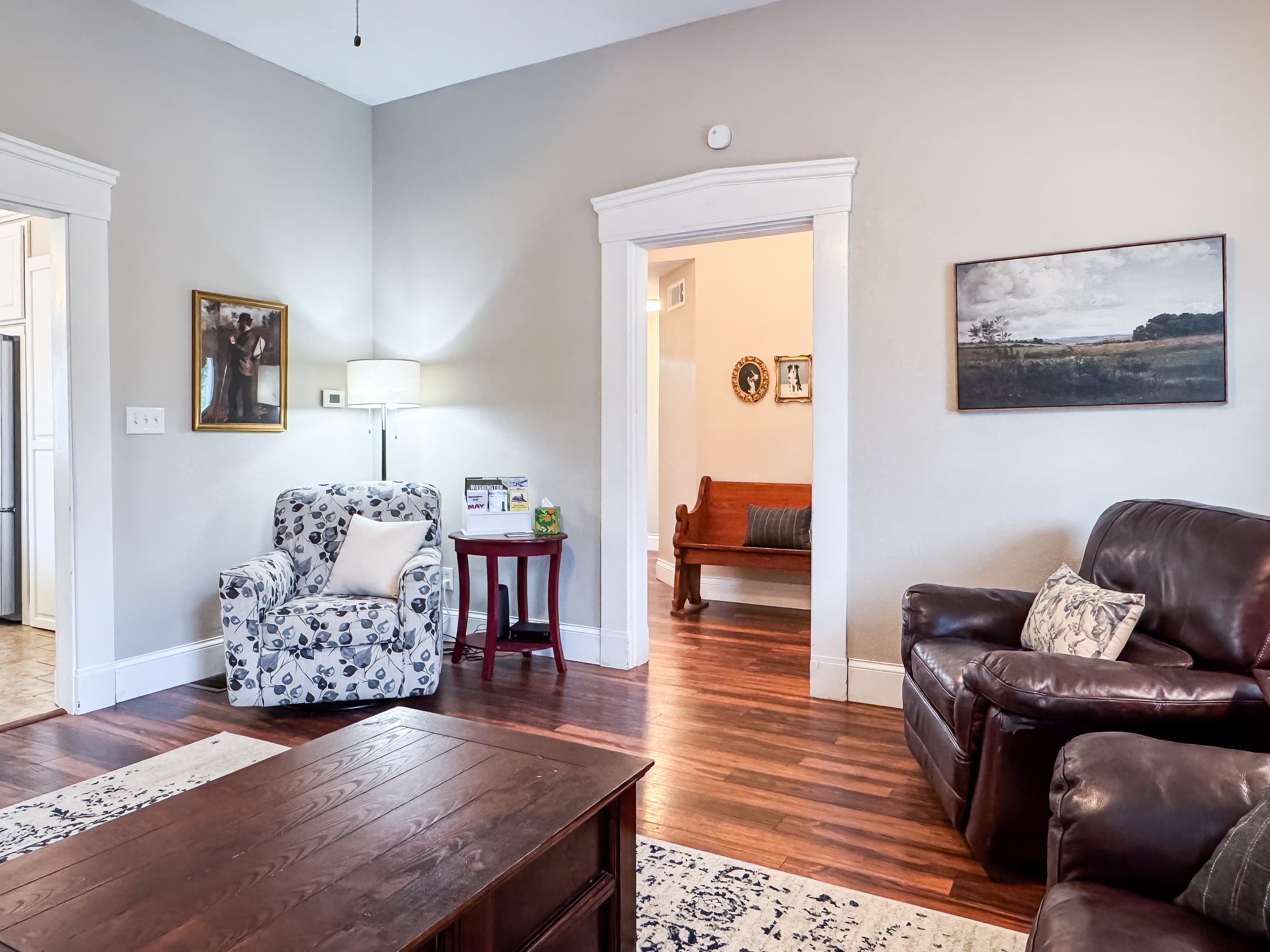 Warm and inviting Great Room with comfy leather couch, loveseat and recliner just off the kitchen for a perfect setup for families/groups to relax and reconnect at Mini Aussie Cottage.