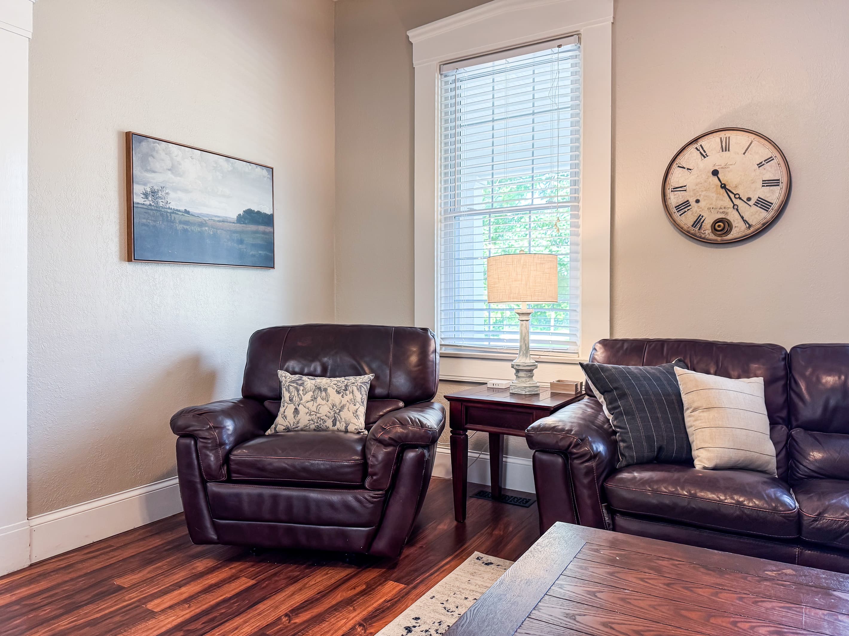 Warm and inviting Great Room with comfy leather couch, loveseat and recliner just off the kitchen for a perfect setup for families/groups to relax and reconnect at Mini Aussie Cottage.