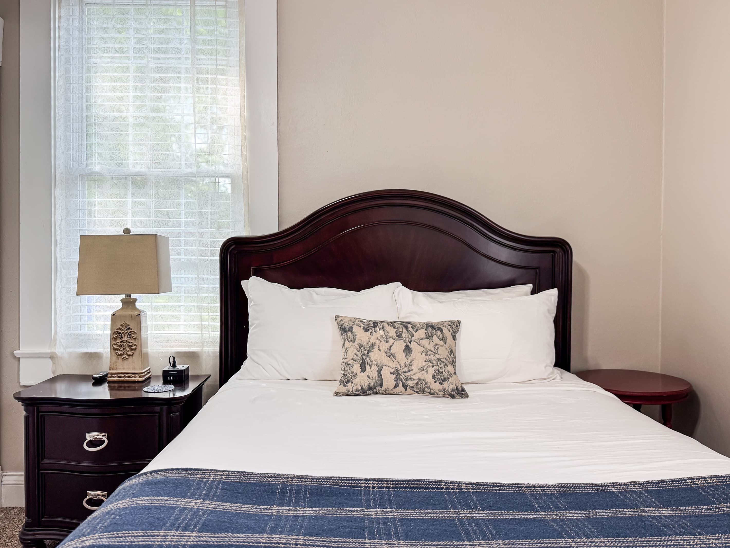 Spacious main level plush queen size bedroom with crisp white linens and full bathroom with combo tub and shower off the hallway at Mini Aussie Cottage.