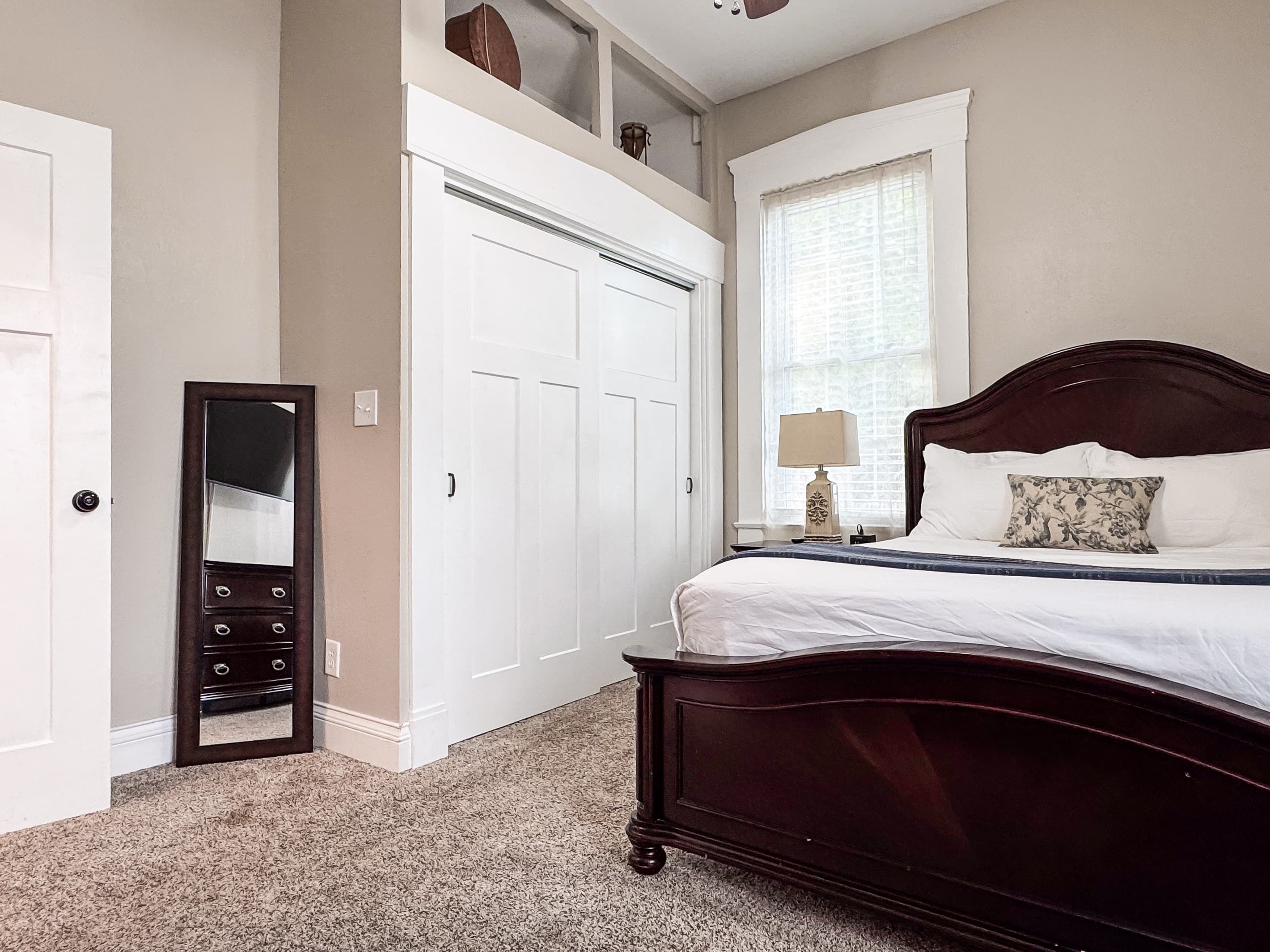 Spacious main level plush queen size bedroom with crisp white linens and full bathroom with combo tub and shower off the hallway at Mini Aussie Cottage.