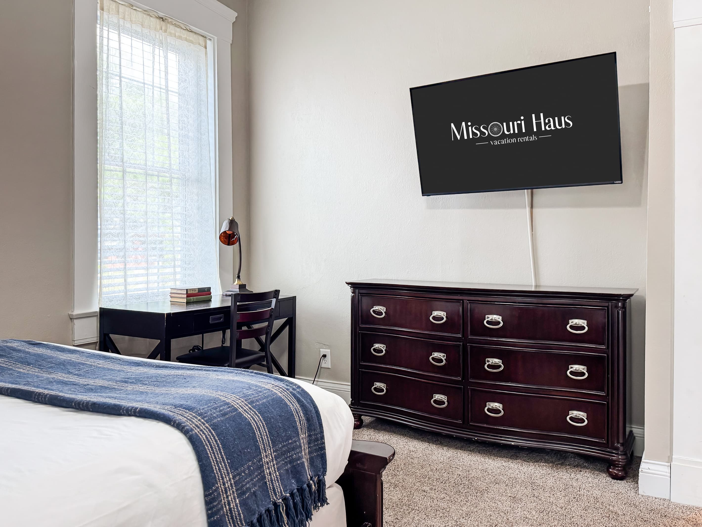 Spacious main level plush queen size bedroom with crisp white linens and full bathroom with combo tub and shower off the hallway at Mini Aussie Cottage.