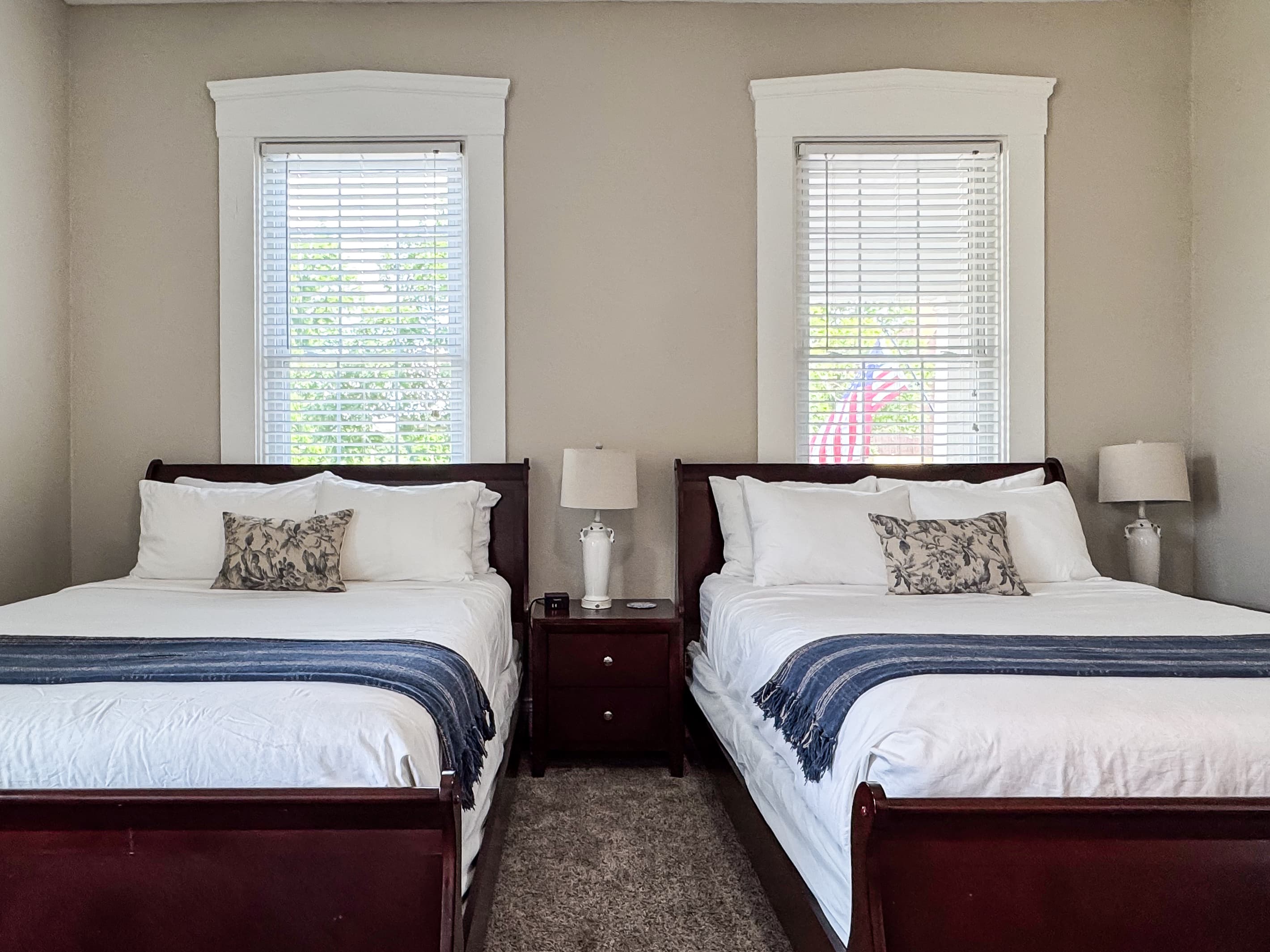 Spacious main level plush queen size bedroom with crisp white linens and full bathroom with combo tub and shower off the hallway at Mini Aussie Cottage.