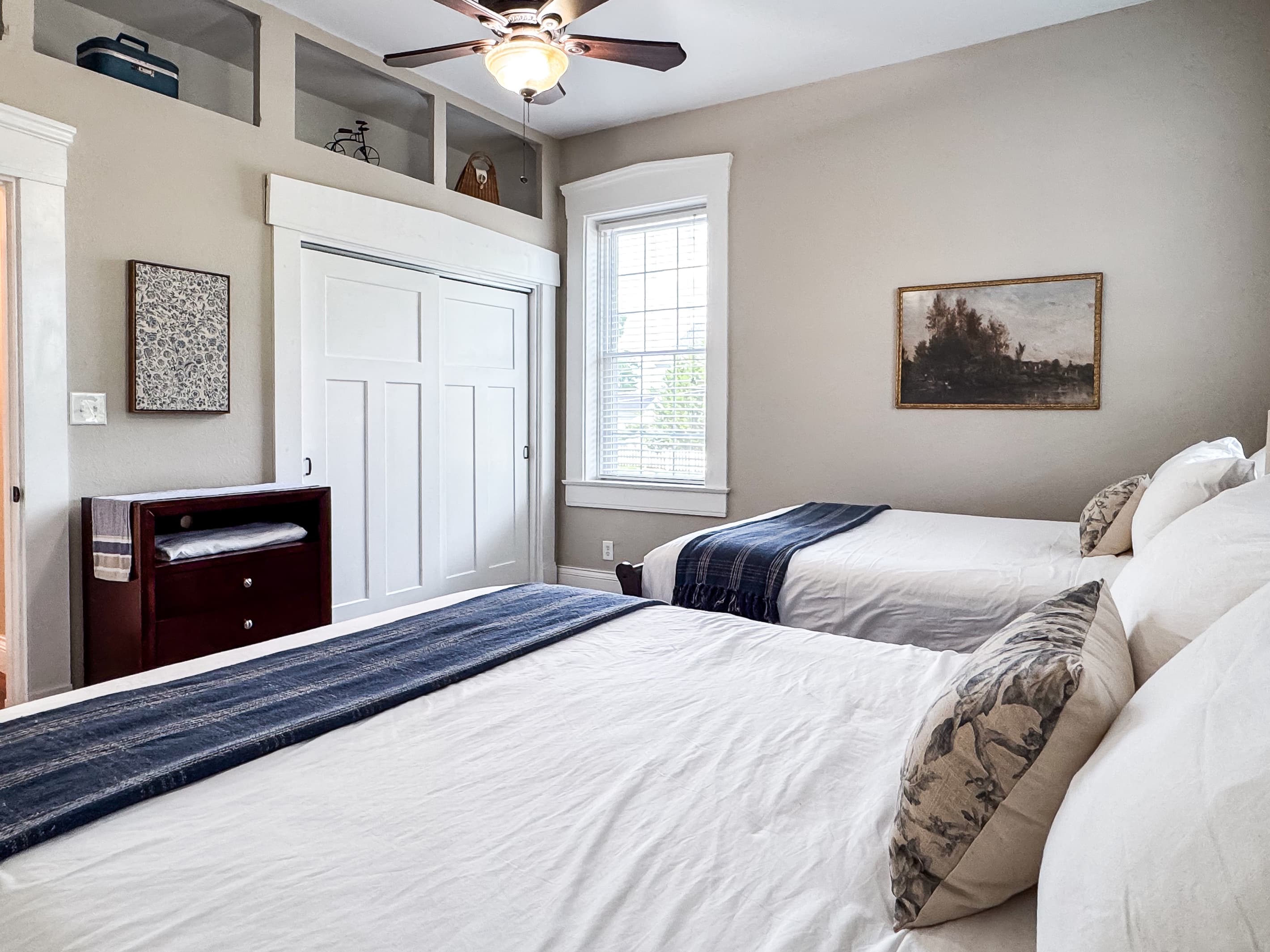 Spacious main level plush queen size bedroom with crisp white linens and full bathroom with combo tub and shower off the hallway at Mini Aussie Cottage.