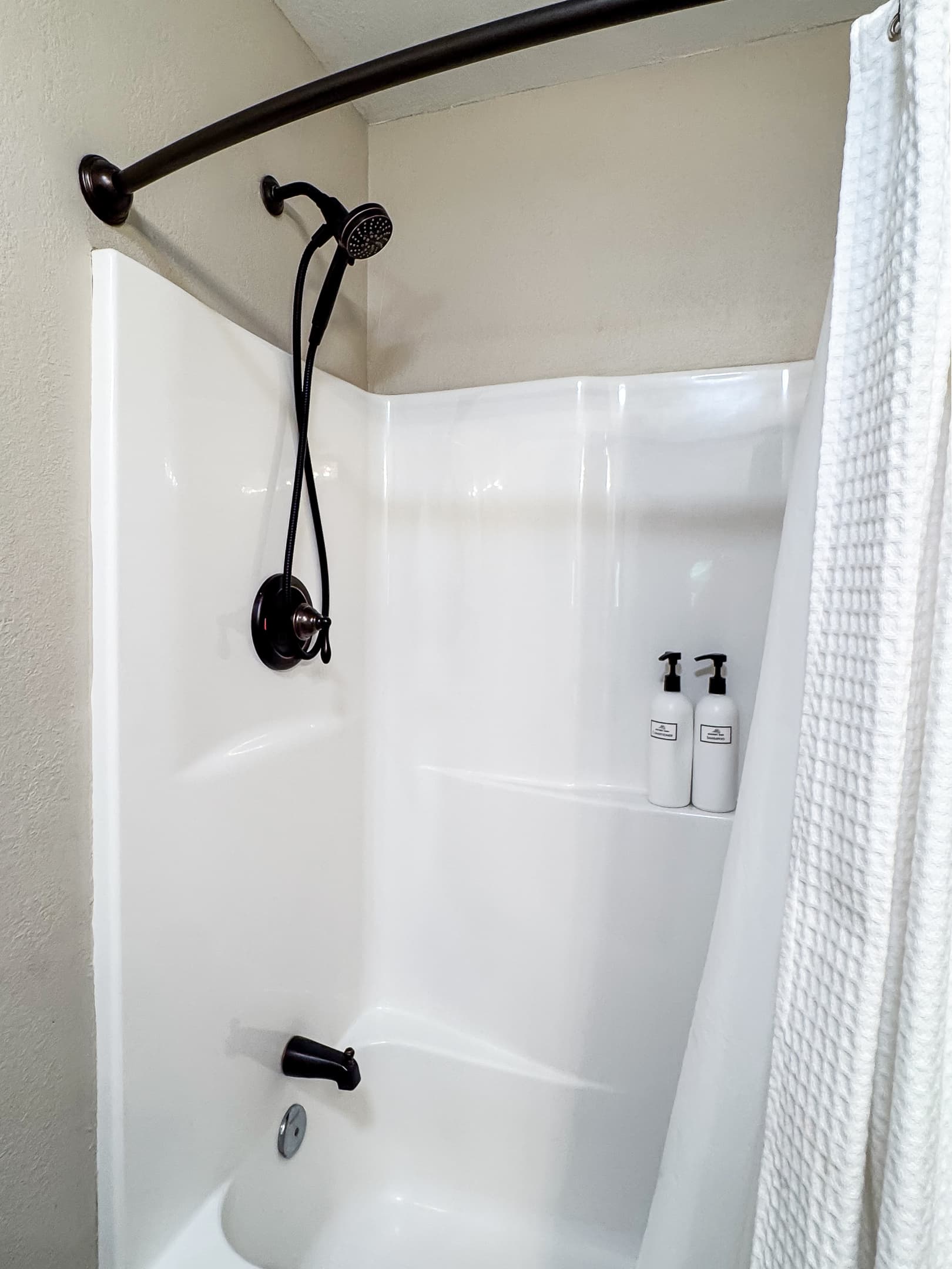 Modern main level full bathroom with combo tub and shower in the hallway at Mini Aussie Cottage.