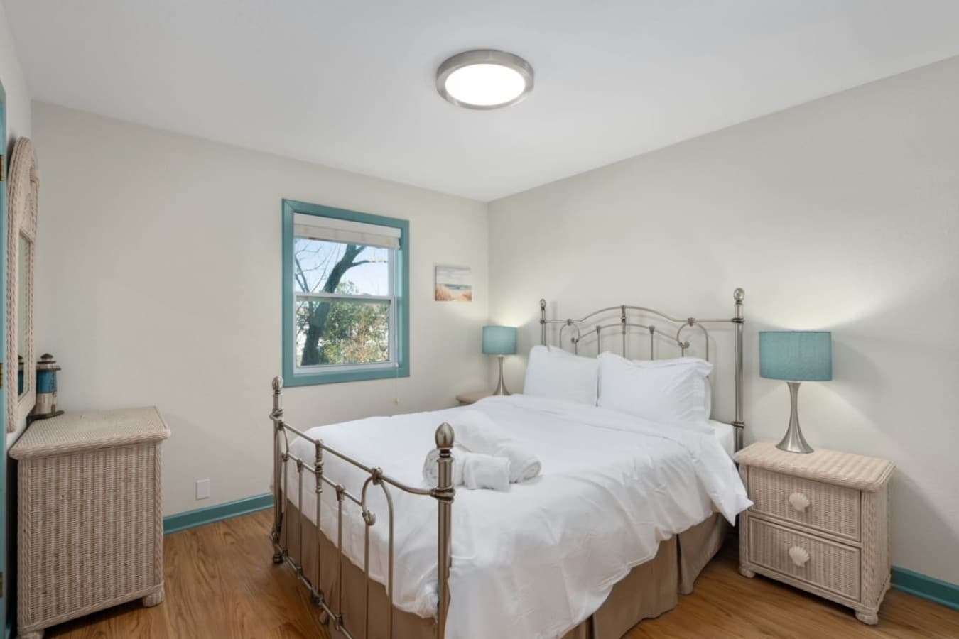 Serene bedroom w/ crisp white bedding & soft coastal touches for restful nights by the sea.