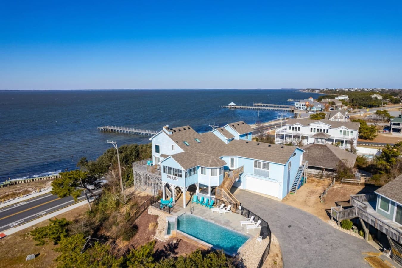 Elevated sound views over the water & neighboring homes, w/ the pier stretching out beyond.