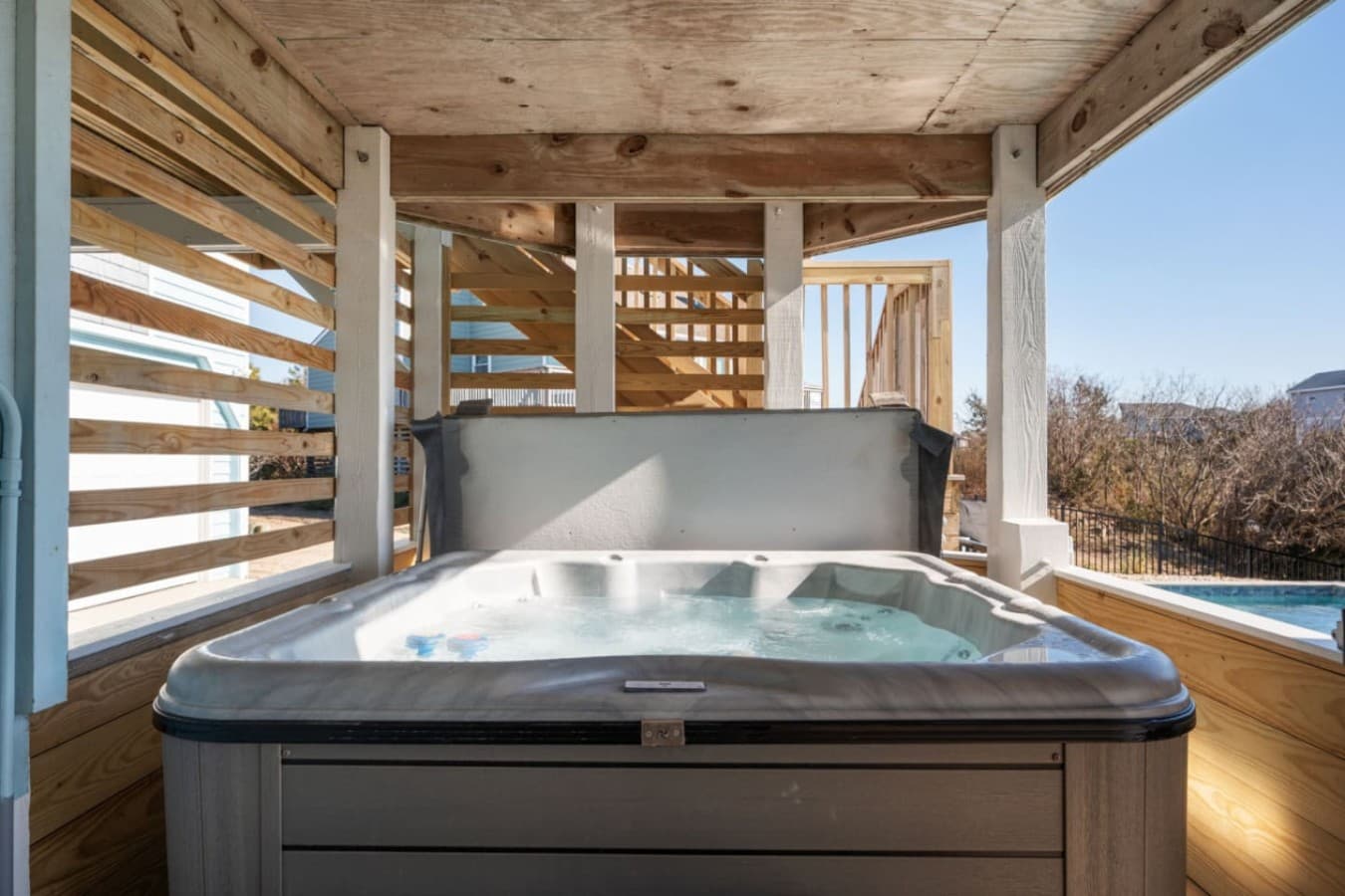 Covered hot tub area w/ privacy slats, perfect for soaking after a full day out.
