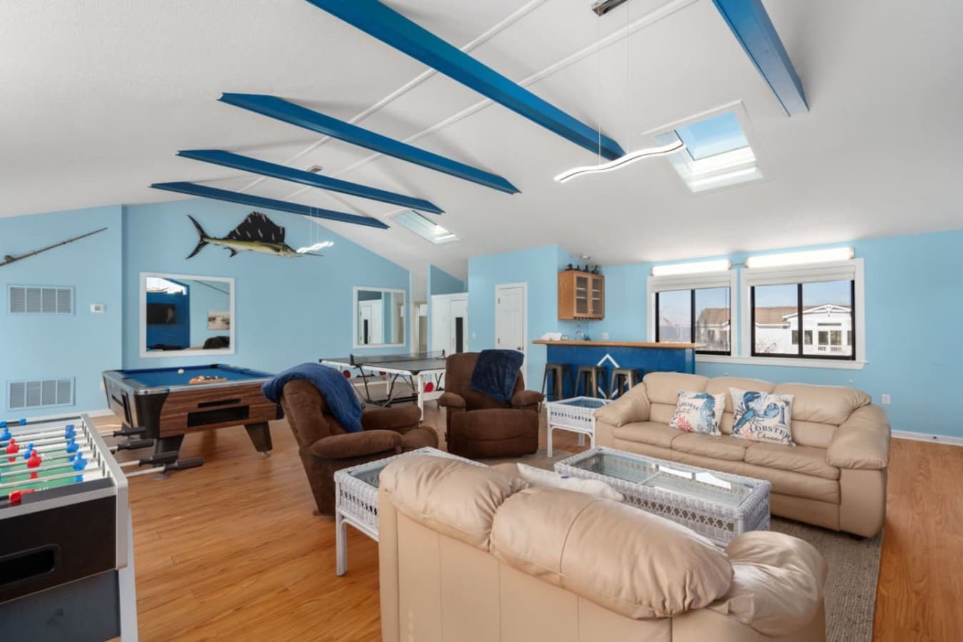 Large living room w/ vaulted ceilings, comfy seating, & relaxed beach vibes.