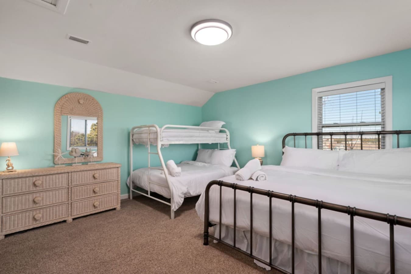 Spacious bunk room w/ multiple beds & playful decor, ideal for kids or group stays.