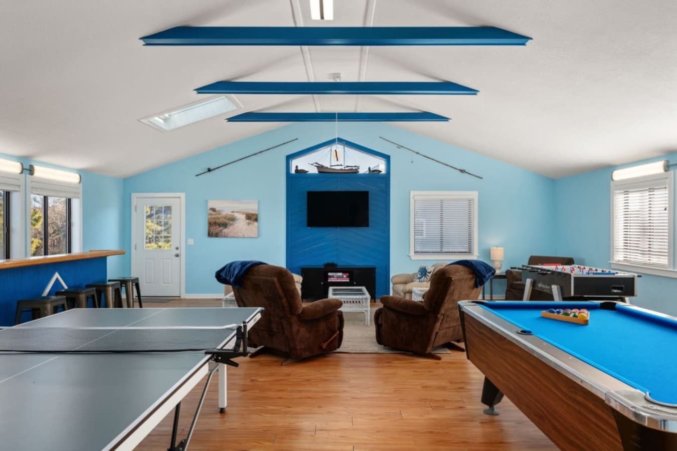 Game room w/ pool table, lounge seating, & nautical ceiling accents for indoor fun.