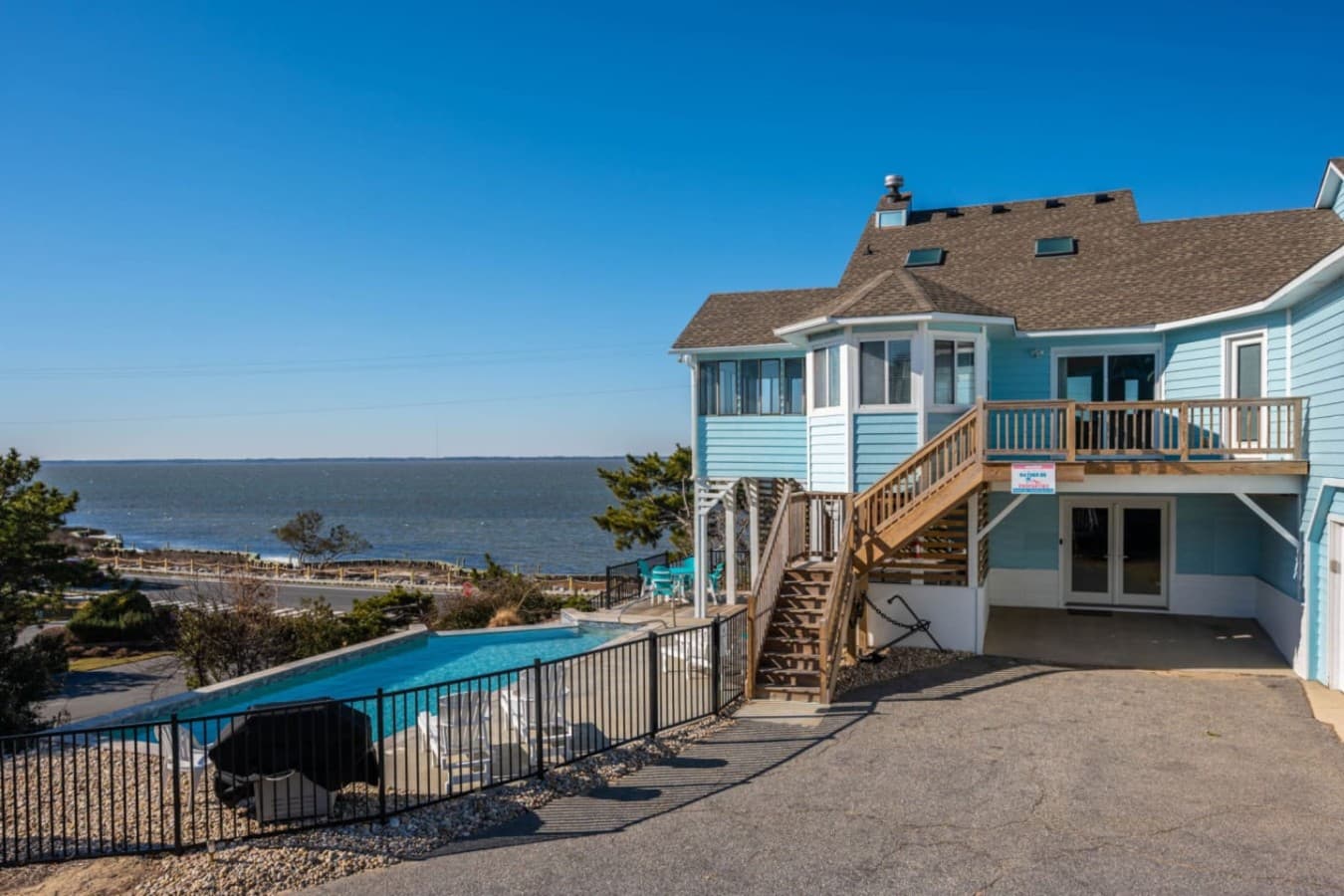 Exterior view of the home w/ private pool & decks overlooking the shoreline.