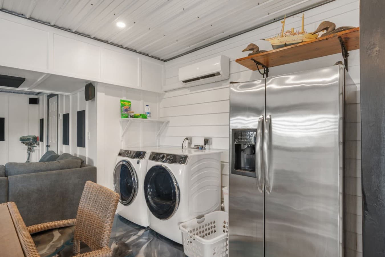 Garage rec room corner w/ full-size washer & dryer, a second fridge & a mini-split.