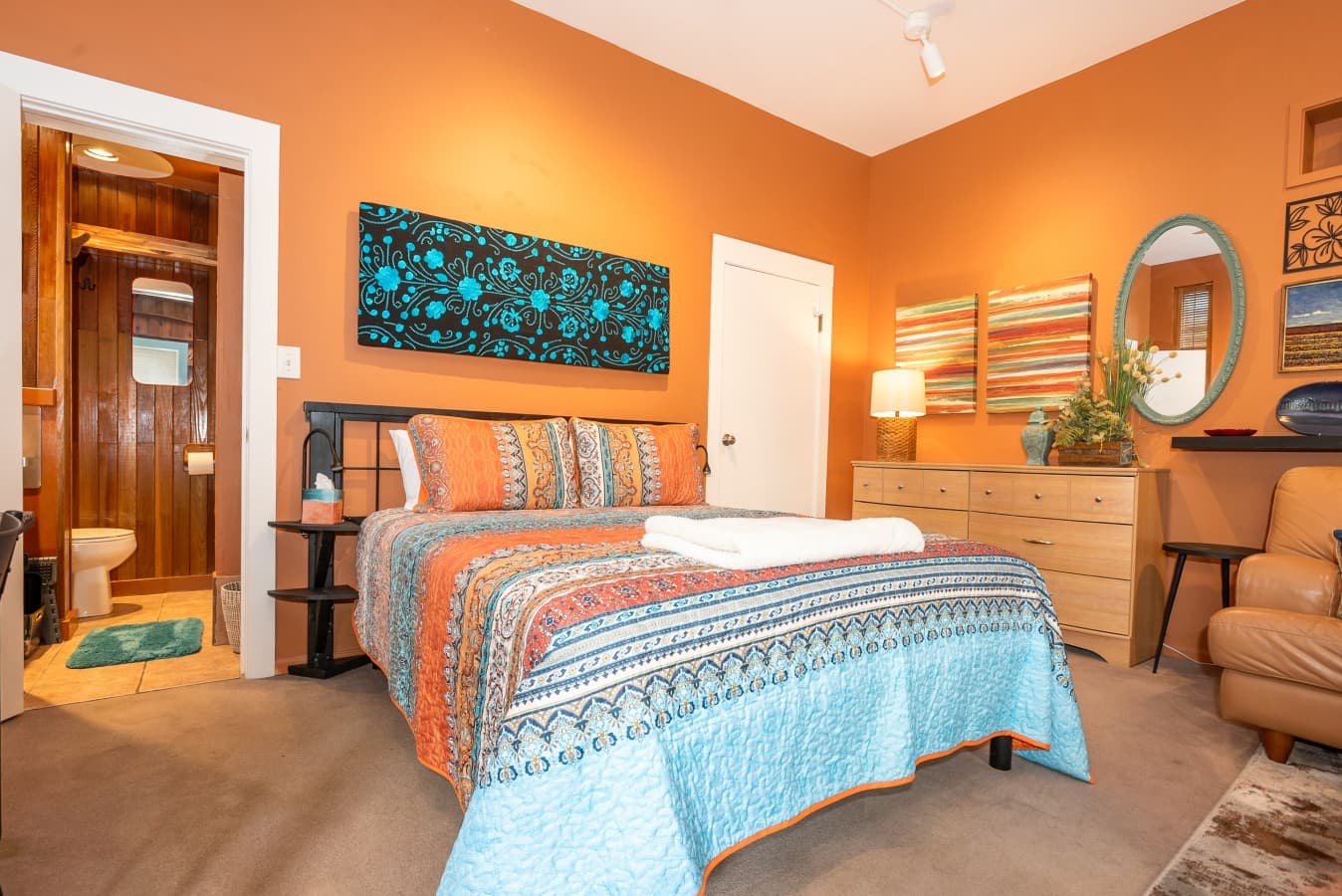 The queen-size bed is dressed with a vibrant, patterned quilt that adds both warmth and character, ensuring a cheerful and restful night's sleep..jpg