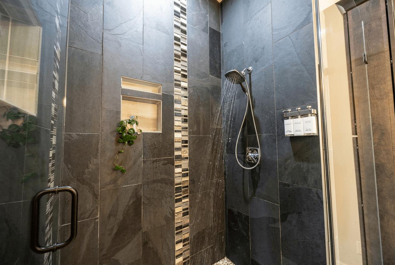 Oversized shower with floor to ceiling tile, large shower head and hand shower. Shower gel, shampoo and conditioner provided.