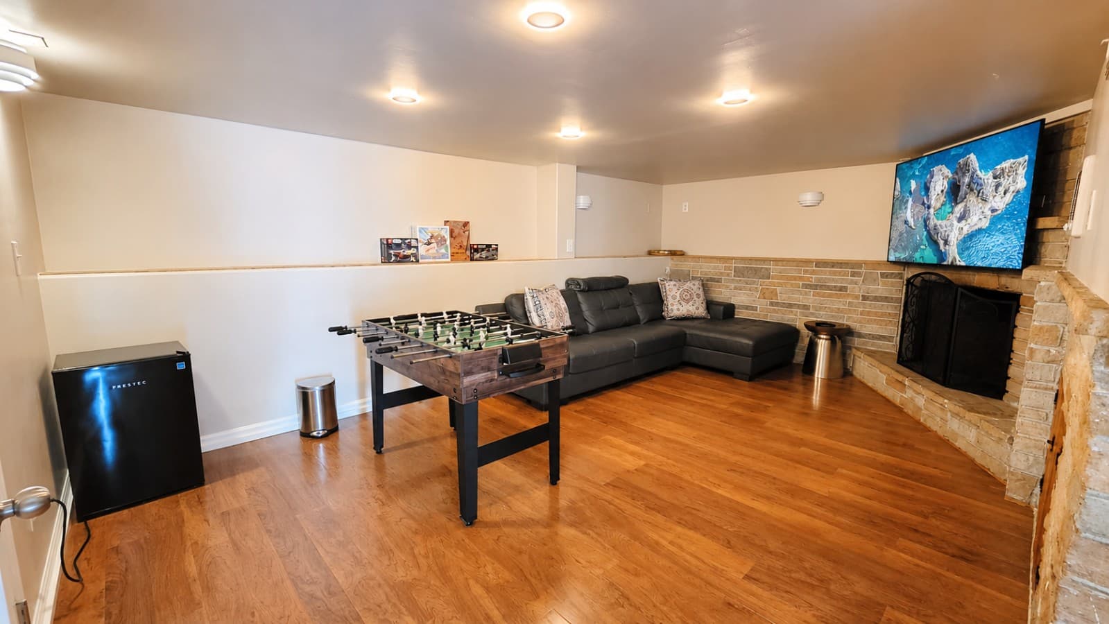 Enjoy foosball, movie nights, and relaxing by the fireplace in this basement entertainment room. .png