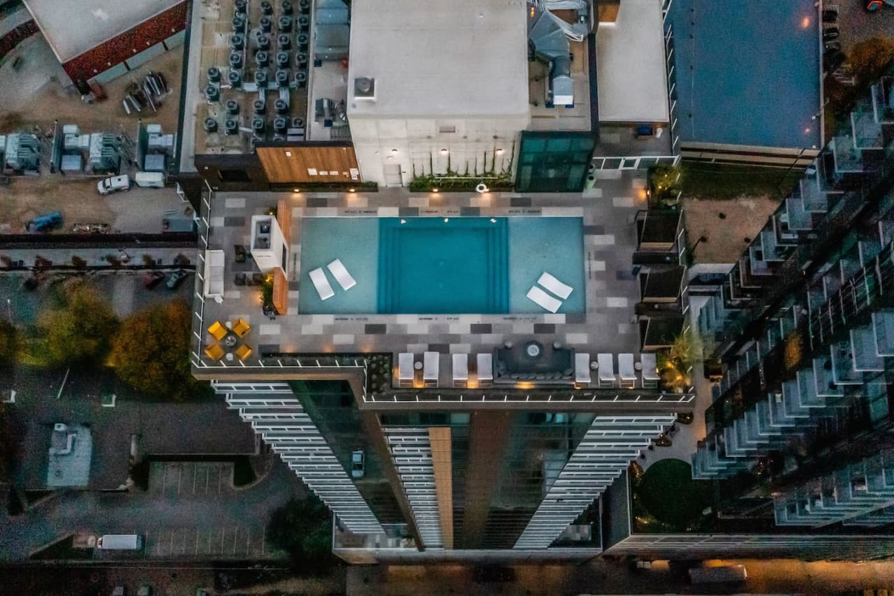 Shaded cabanas and outdoor lounge seating line our rooftop swimming pool, overlooking shimmering waters and the breathtaking city below.