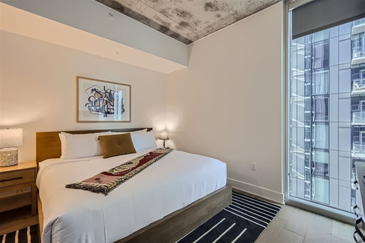 A luxurious bedroom envelops you in a cozy oasis, with great bedding, soft lighting, and soothing decor, creating a tranquil haven for rest and relaxation.