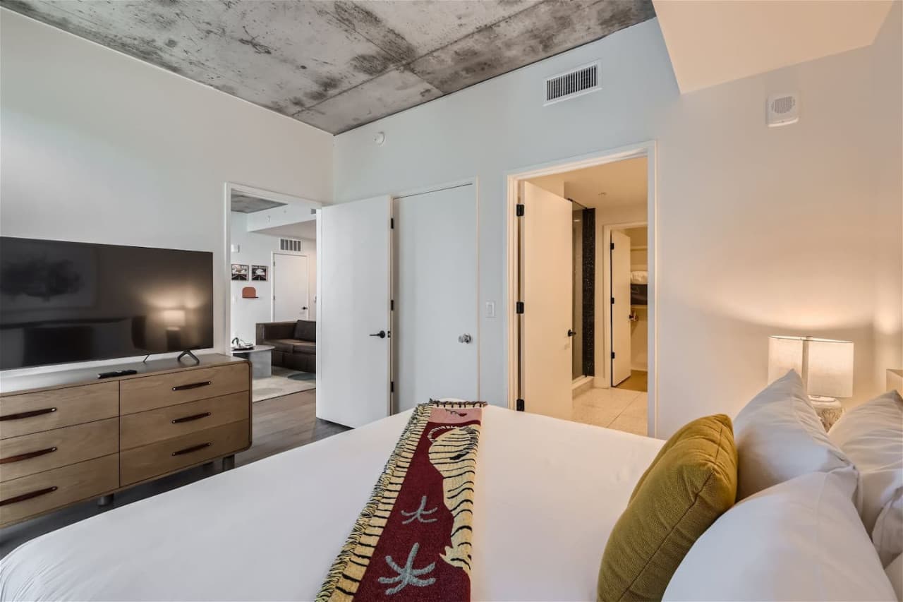Master bedroom featuring an en-suite bathroom, large Smart TV for streaming and a king size bed.